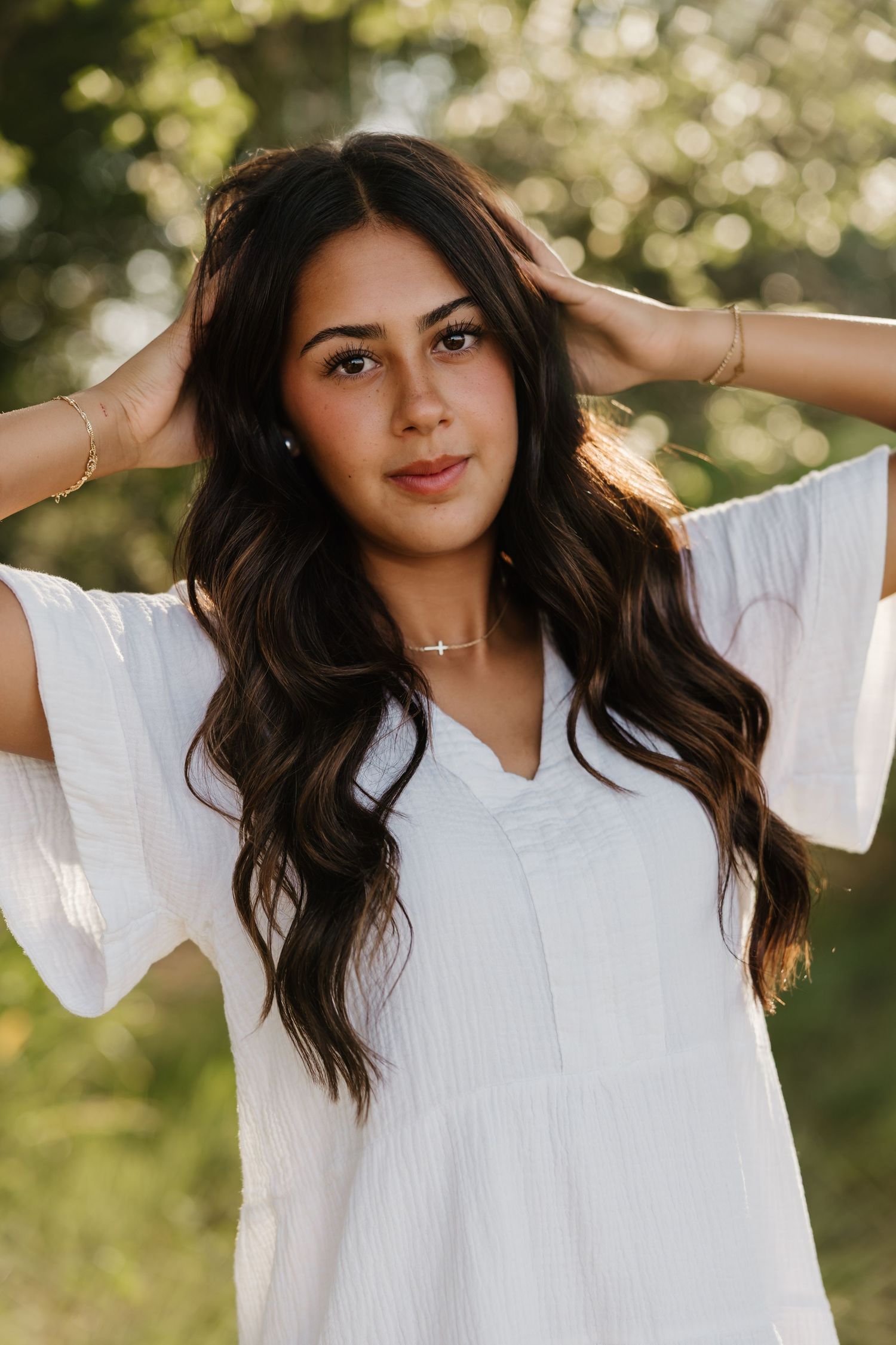 A girl taking senior portraits in Tulia, Texas wearing a cross necklace