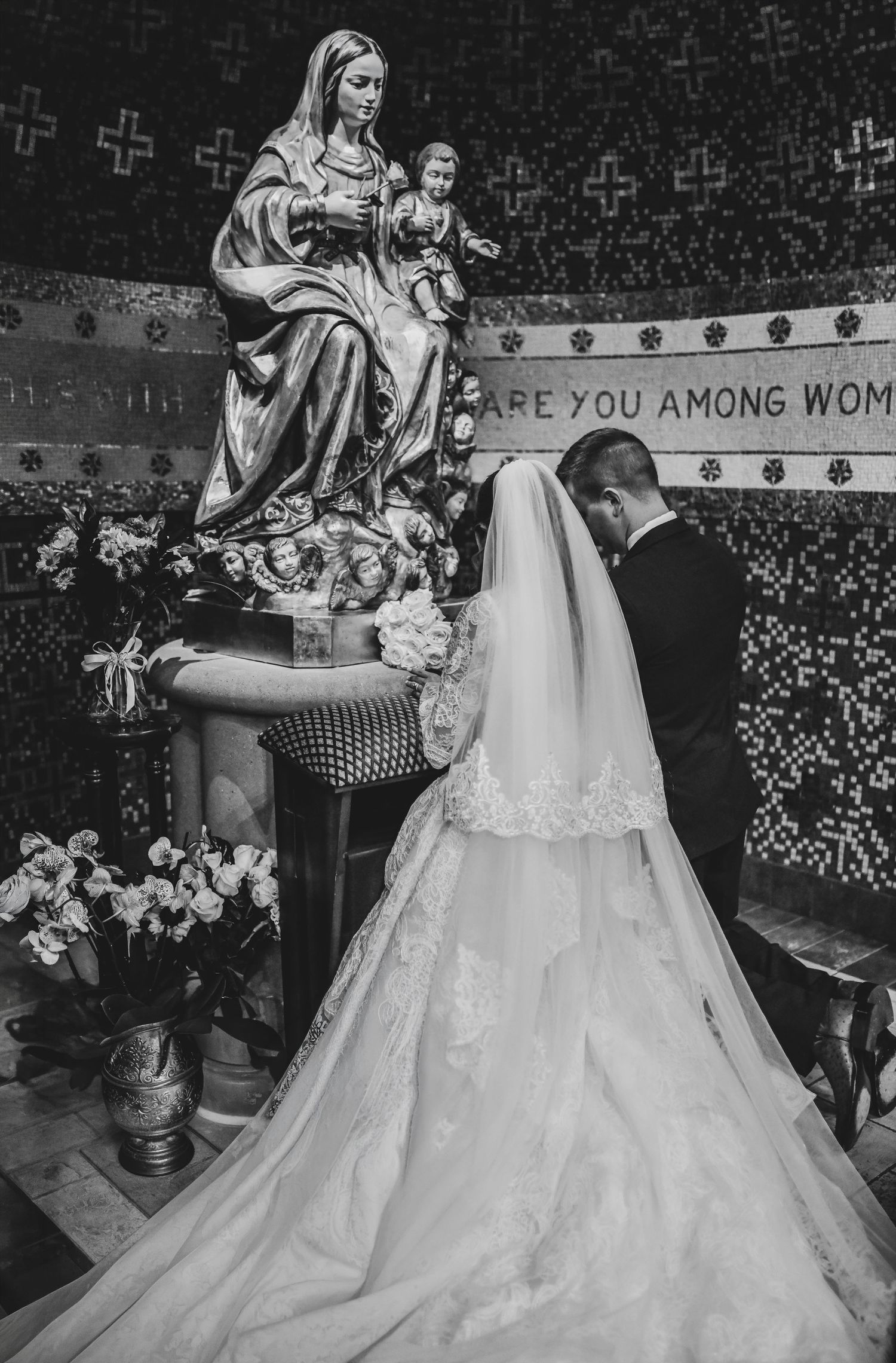 Bride and groom presenting flowers to the Blessed Virgin Mary during Catholic wedding