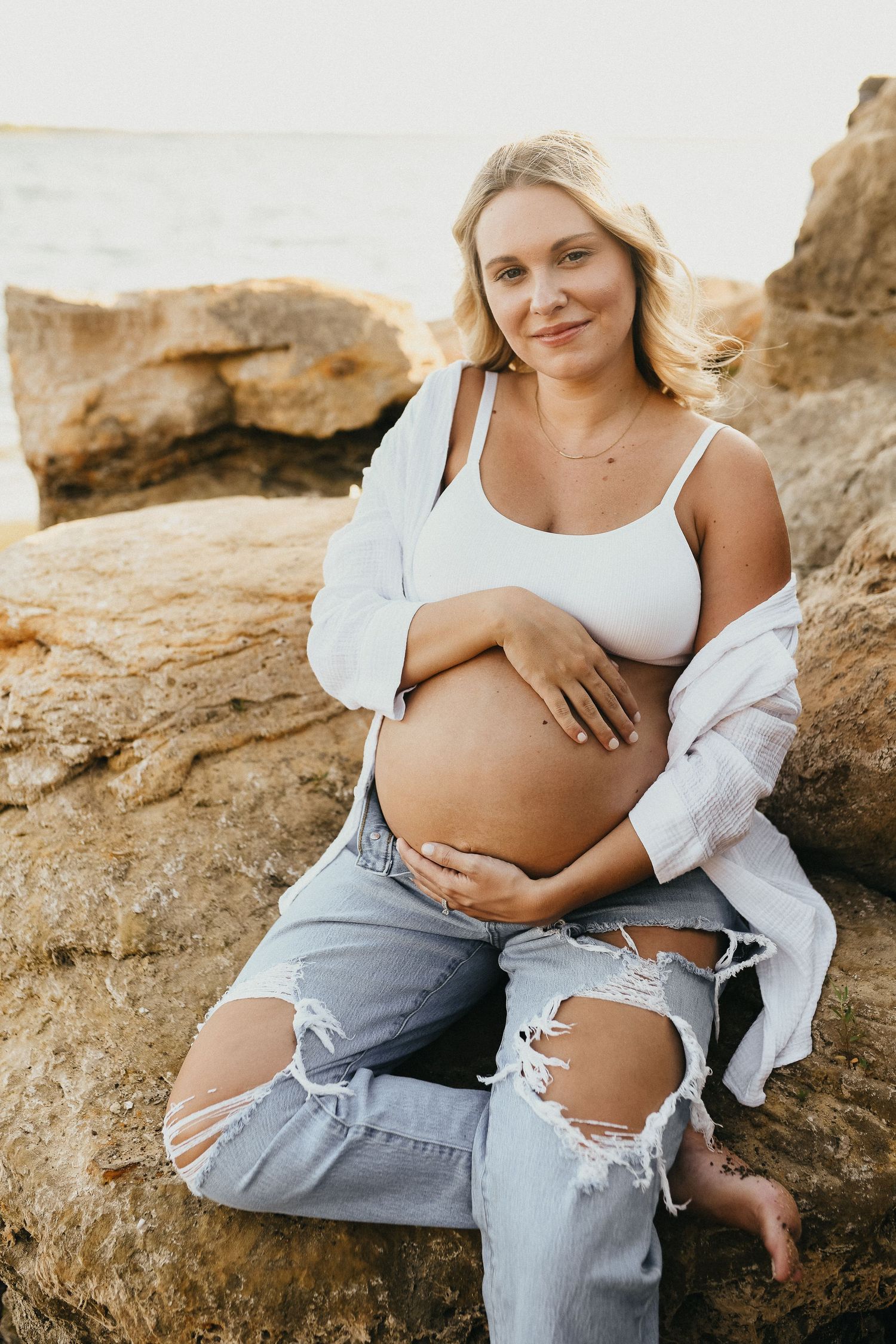 Expecting mother posing on the rocks during her Lake Grapevine maternity session