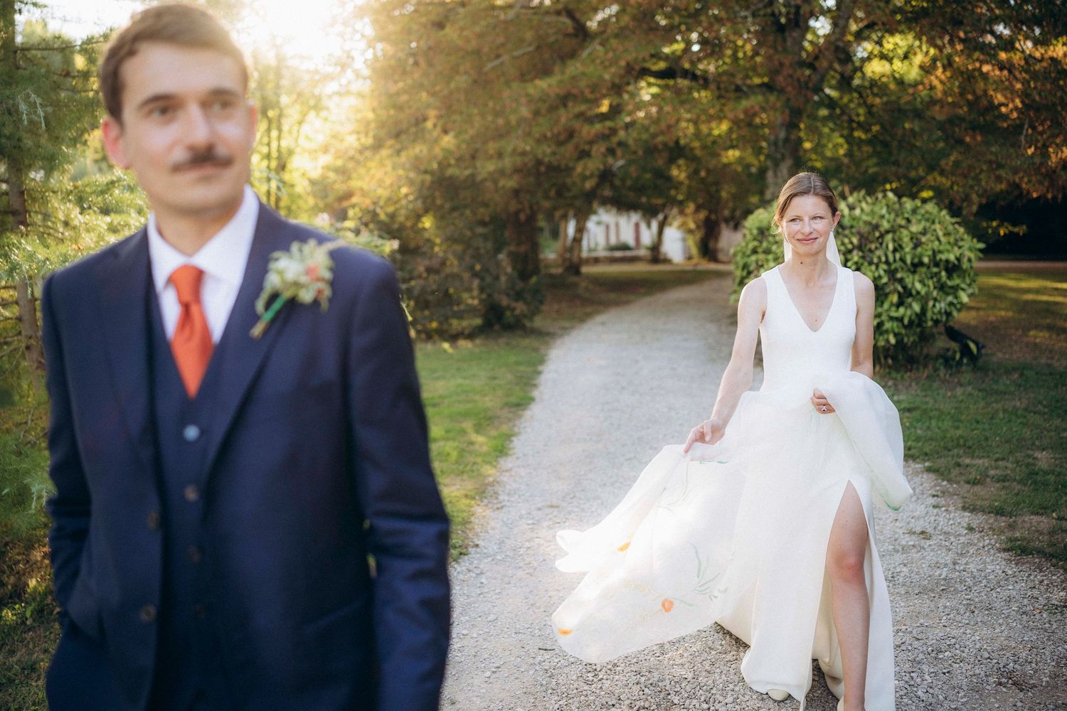 A romantic black and white wedding photograph showing a tender embrace in a natural outdoor setting.
