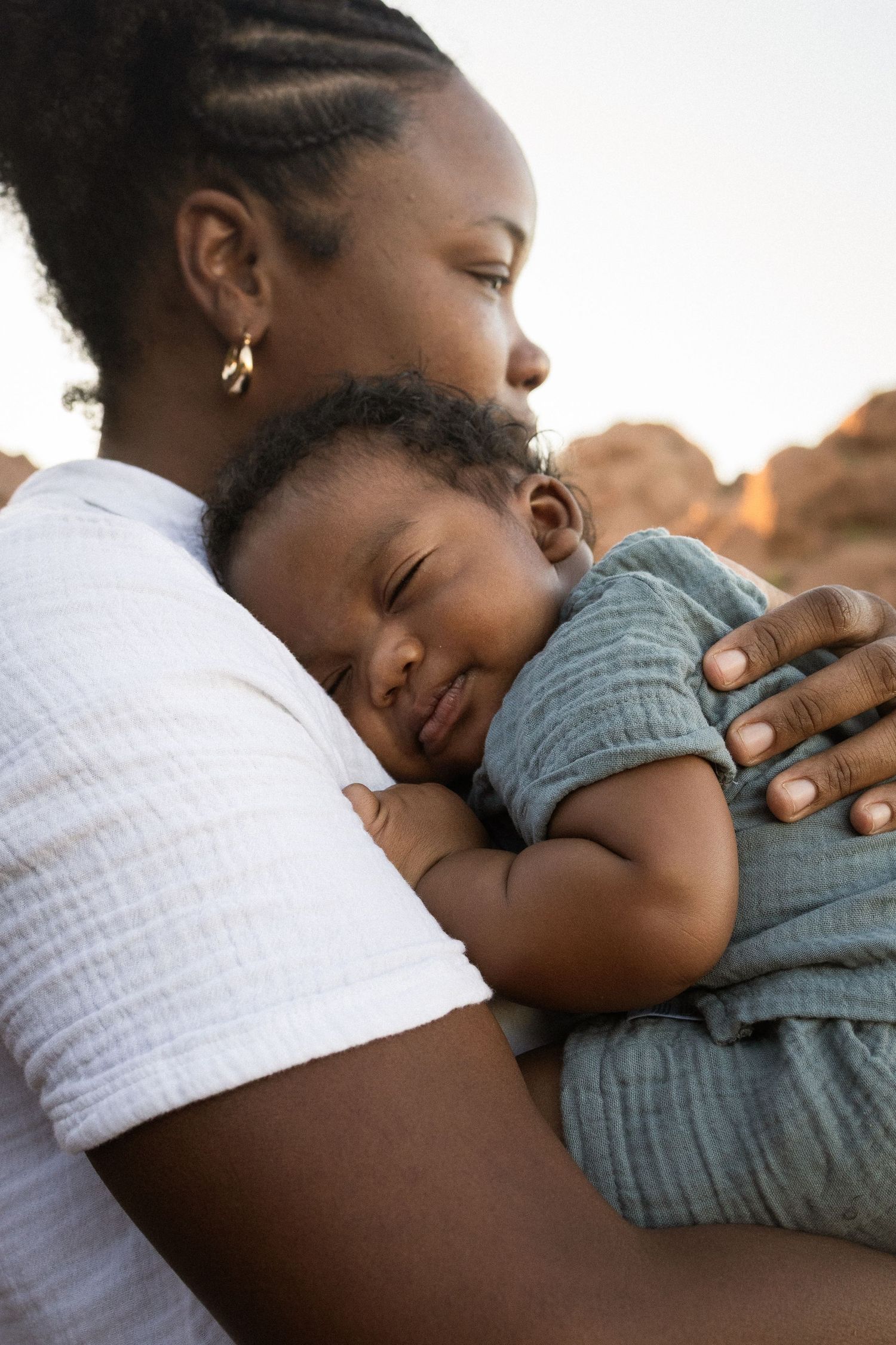 A mother tenderly holds her sleeping newborn baby close to her chest at Papago Park in Phoenix.