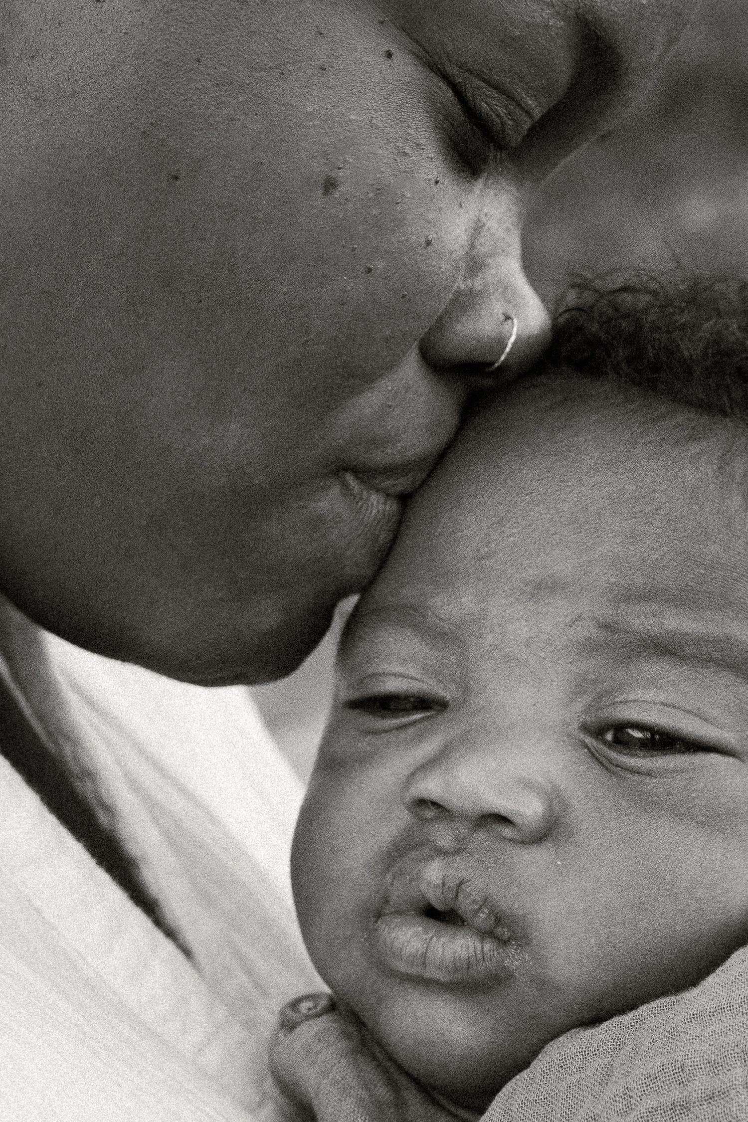 Black and white photo of a mother tenderly kissing her newborn baby on the forehead at Papago Park in Phoenix.