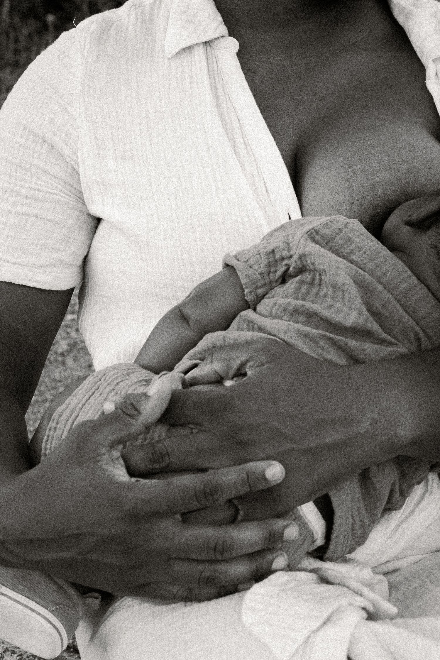 Black and white photo of a mother breastfeeding her newborn baby, cradling the infant tenderly in her arms at Papago Park in Phoenix.