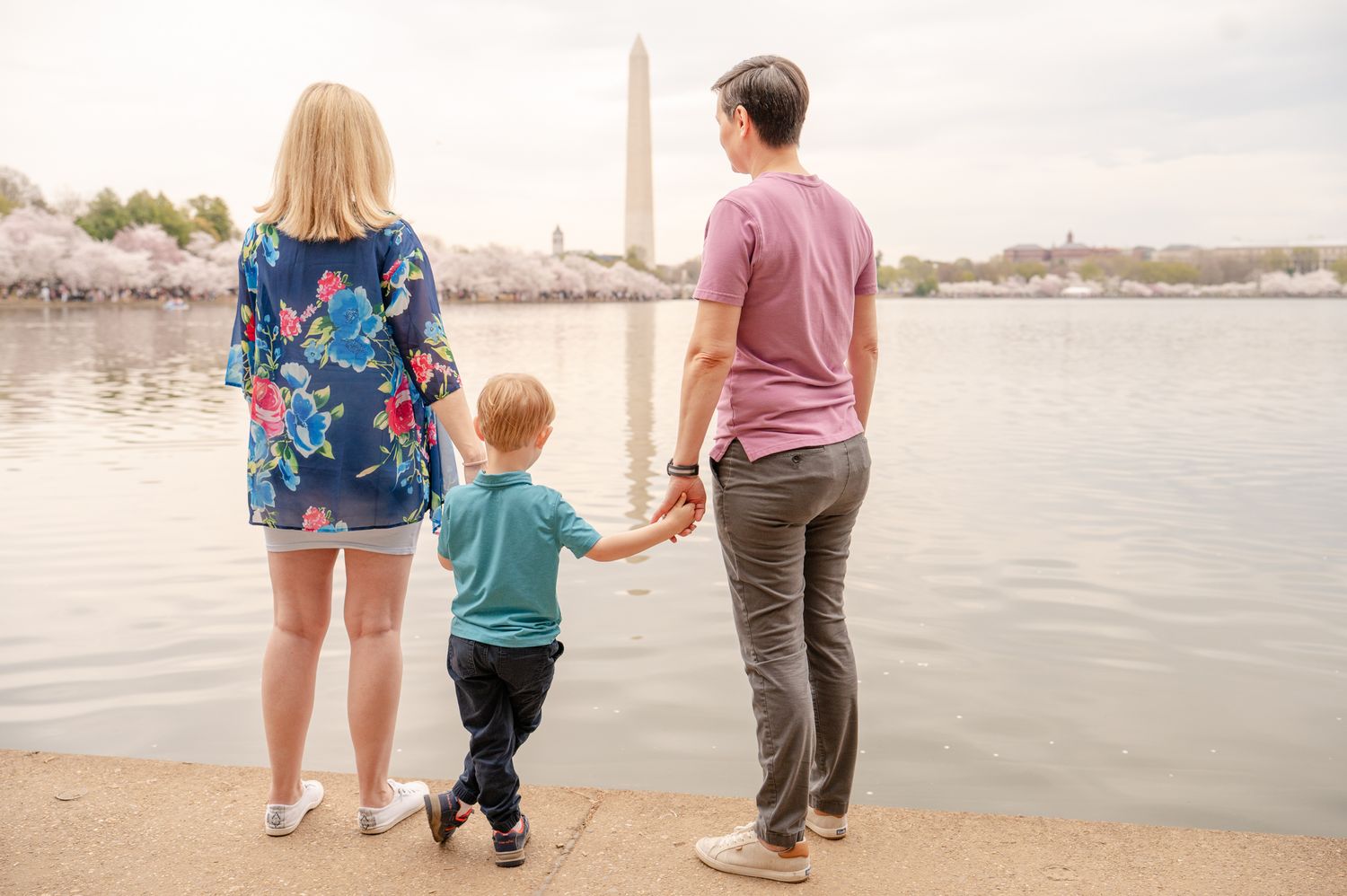 A family looks out at the cherry blossoms across the Tidal Basin in Washington DC - example of not showing children's faces in photos.