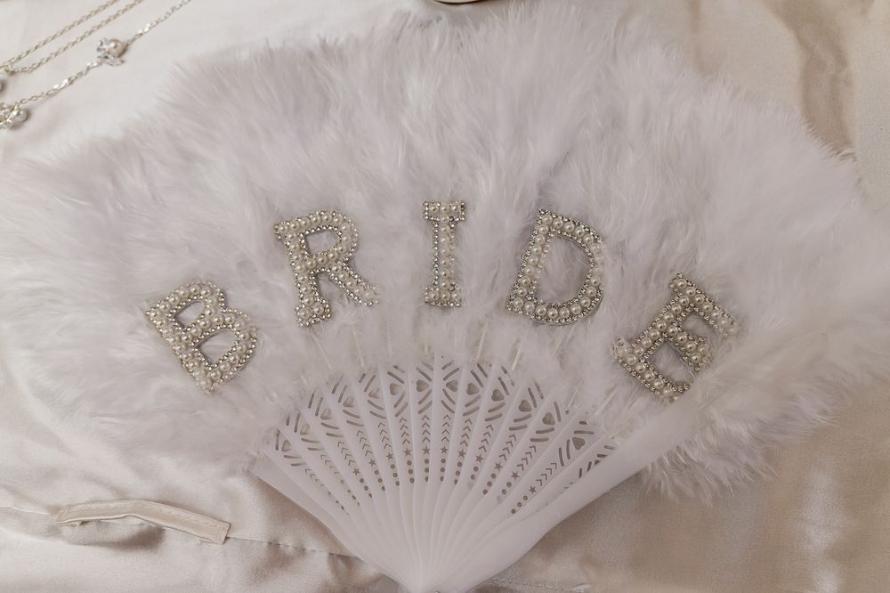 White feather hand fan with rhinestone BRIDE letters, perfect bridal accessory for weddings and bachelorette parties.
