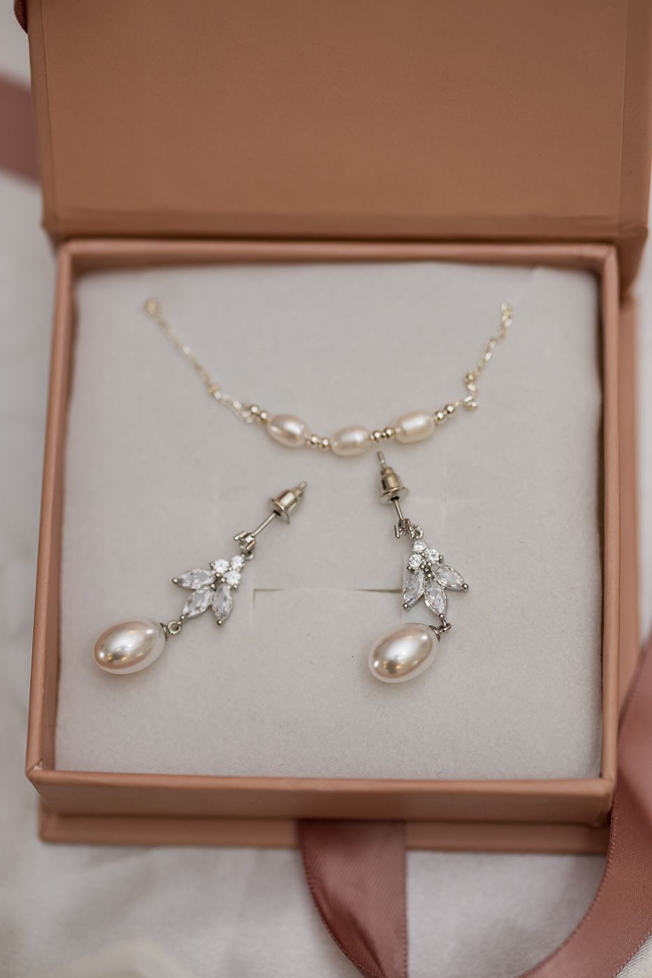 Pearl and crystal drop earrings with matching pearl necklace displayed in a pink gift box.