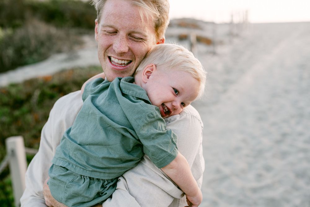 little one year old hugging dad with a big smile on his face.