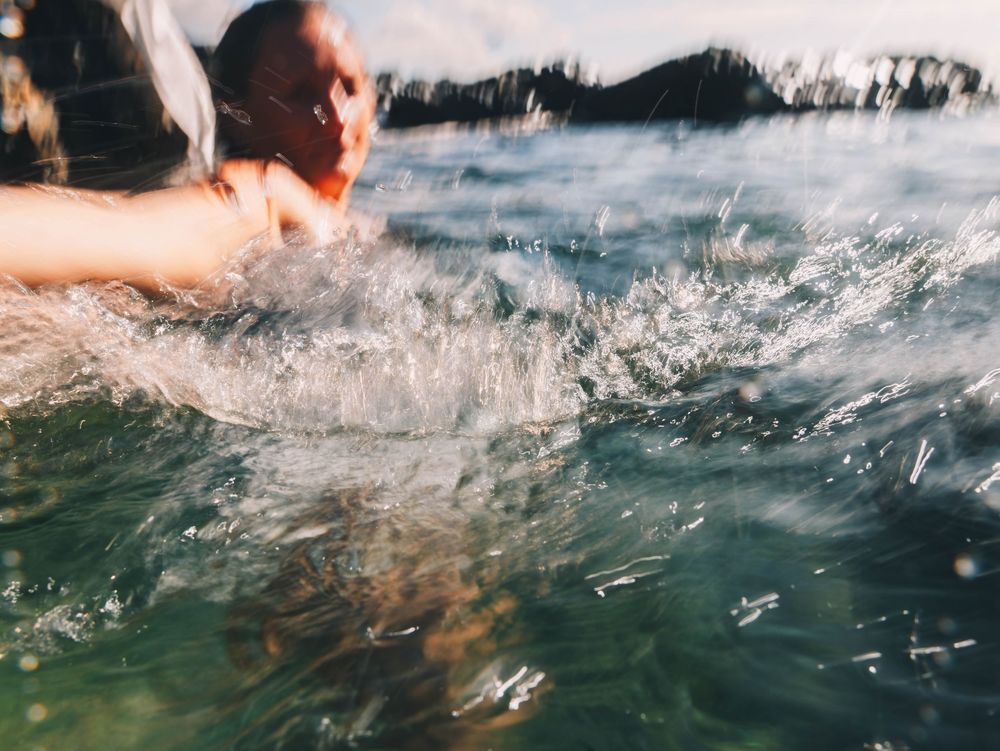 woman splashing water in long exposure shot in the Tide of Her underwater portrait session