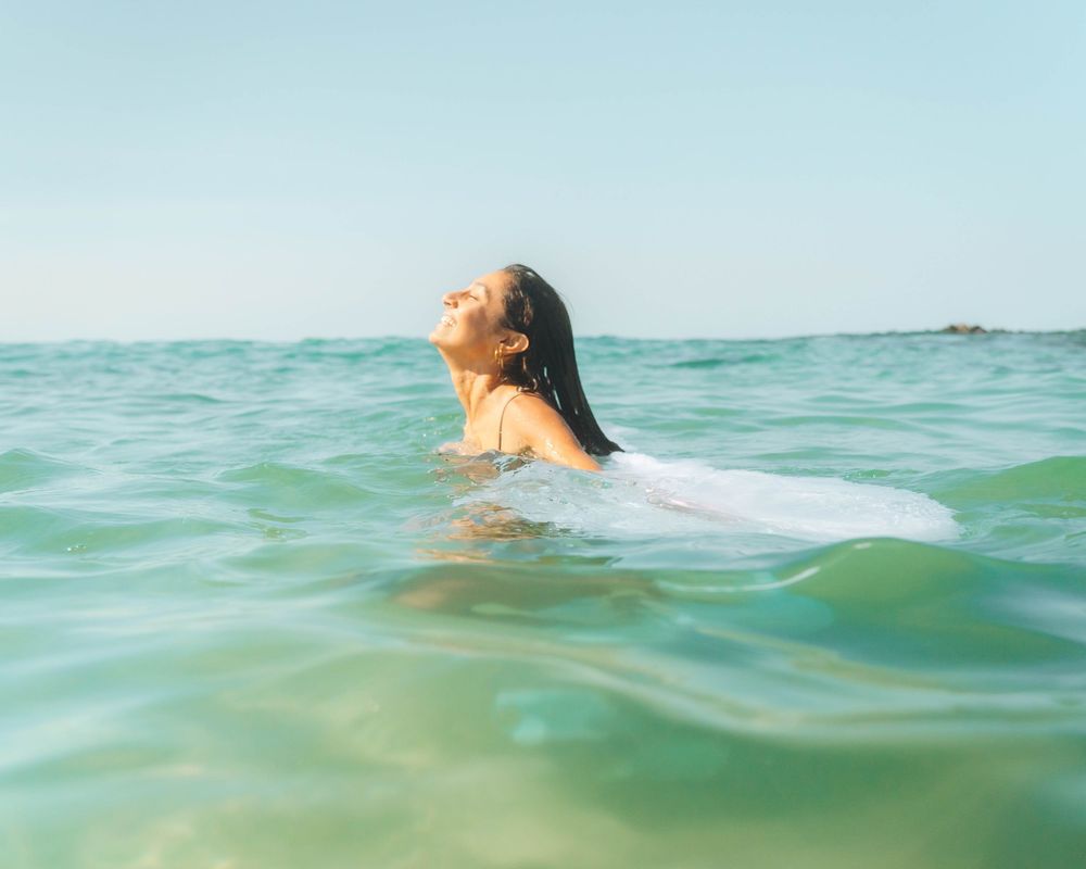 woman laughing into the light on a midday shoot at Crescent Head NSW in the ocean underwater portrait session
