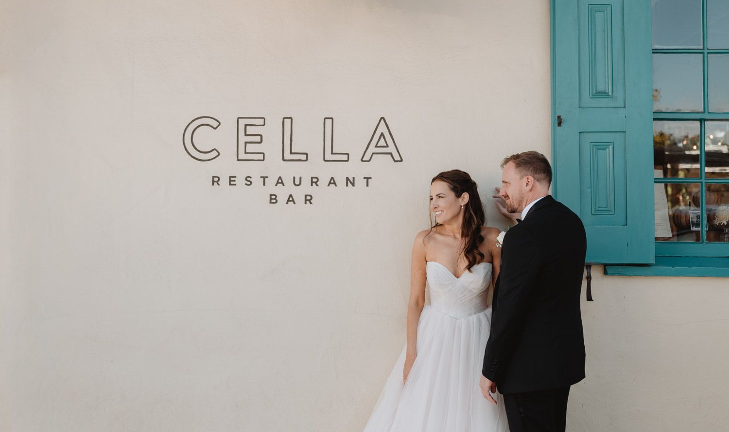 a bride and groom stand next to Cella restaurant in monterey california at one of the best places to eat in Monterey