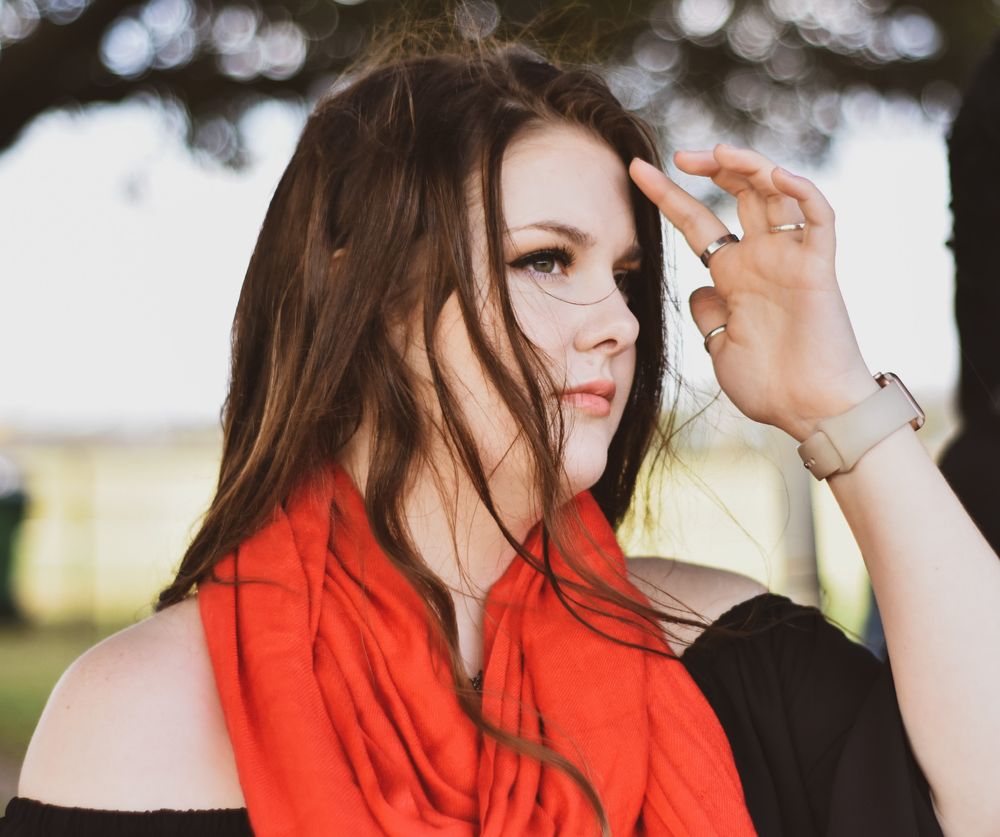 Outdoor portrait of a young woman wearing a red scarf
