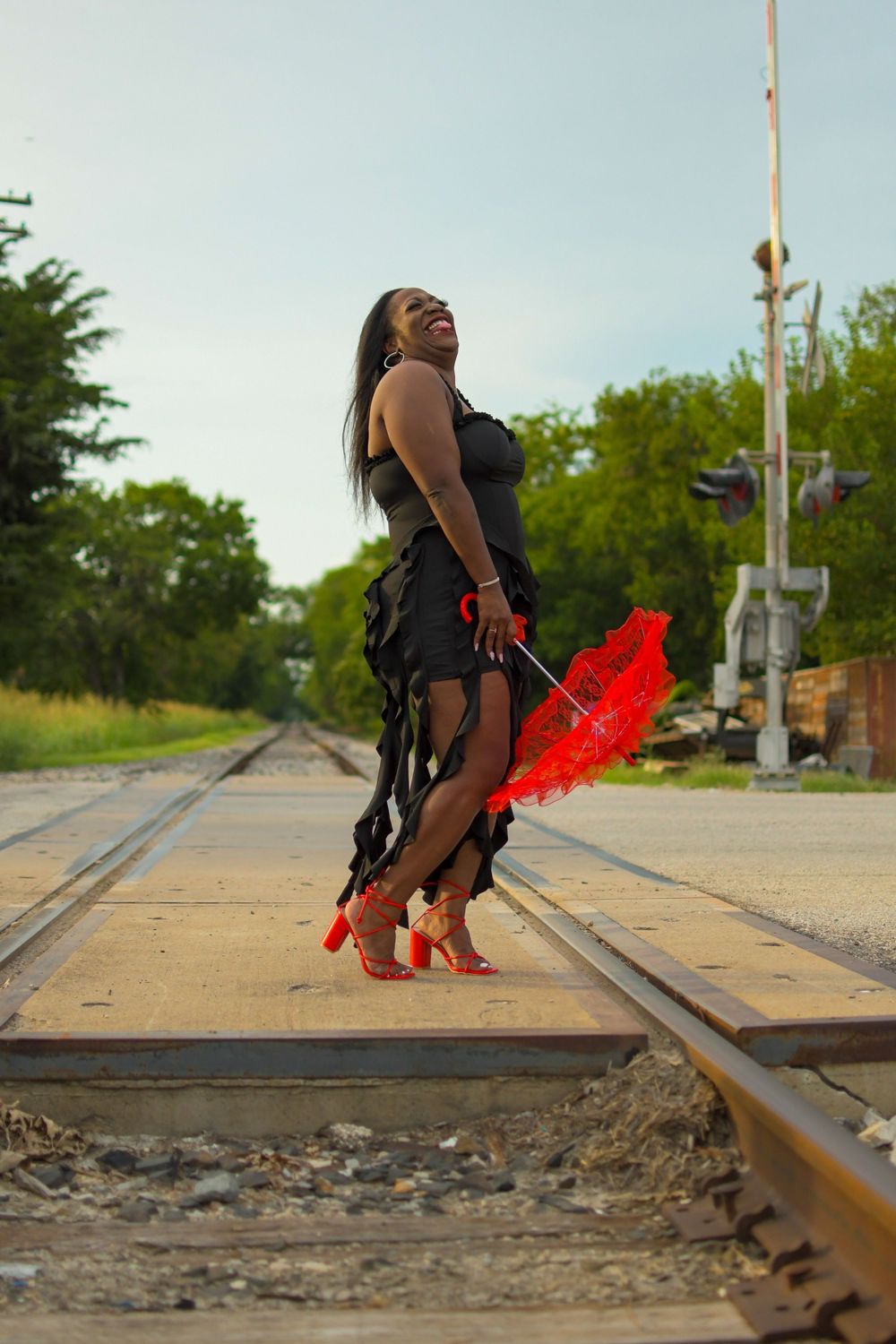 Creative outdoor portrait of a woman posing on railroad tracks
