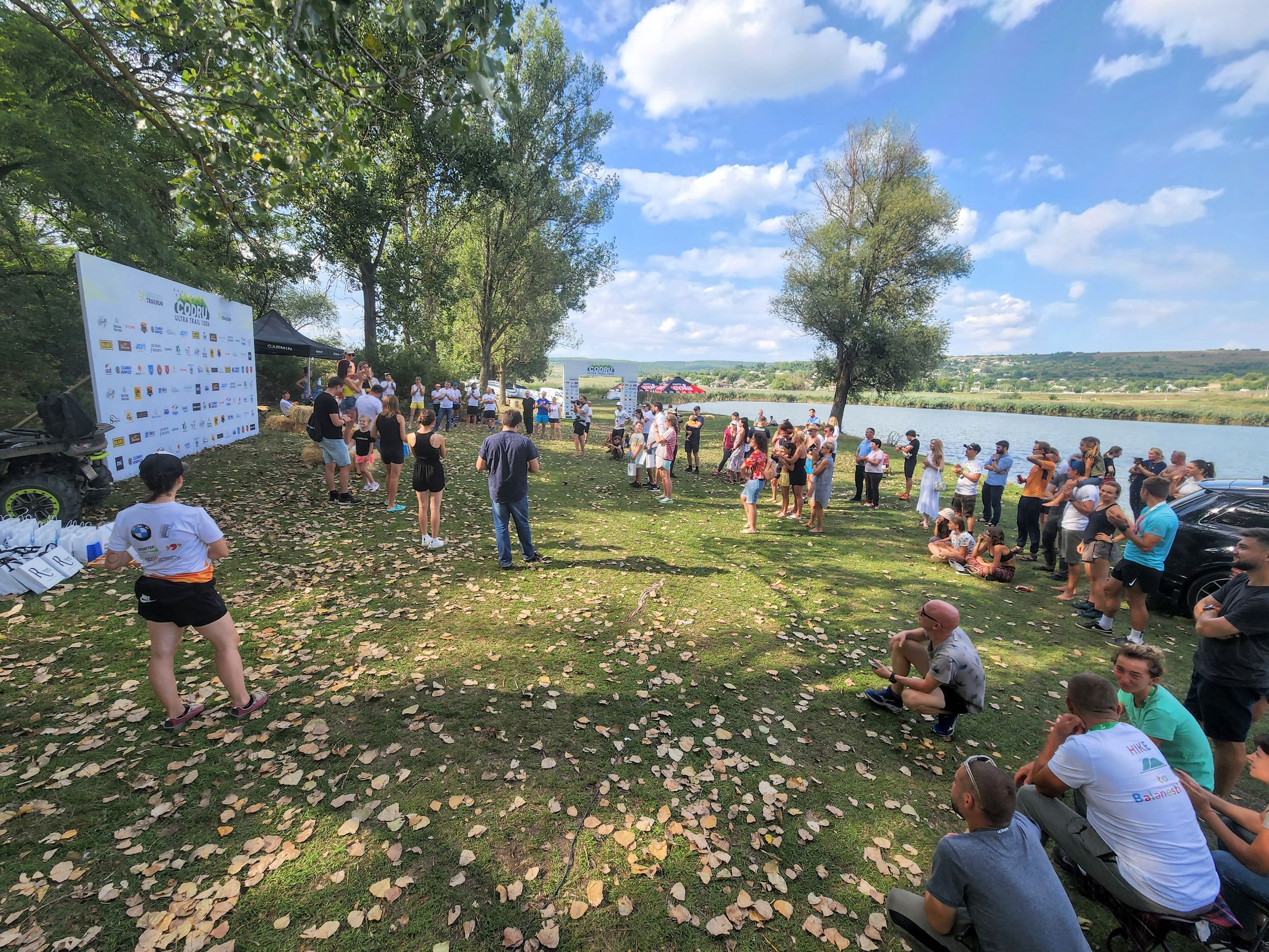 Large crowd of trail running participants gathered outdoors near lake at Codru Ultra Trail event.