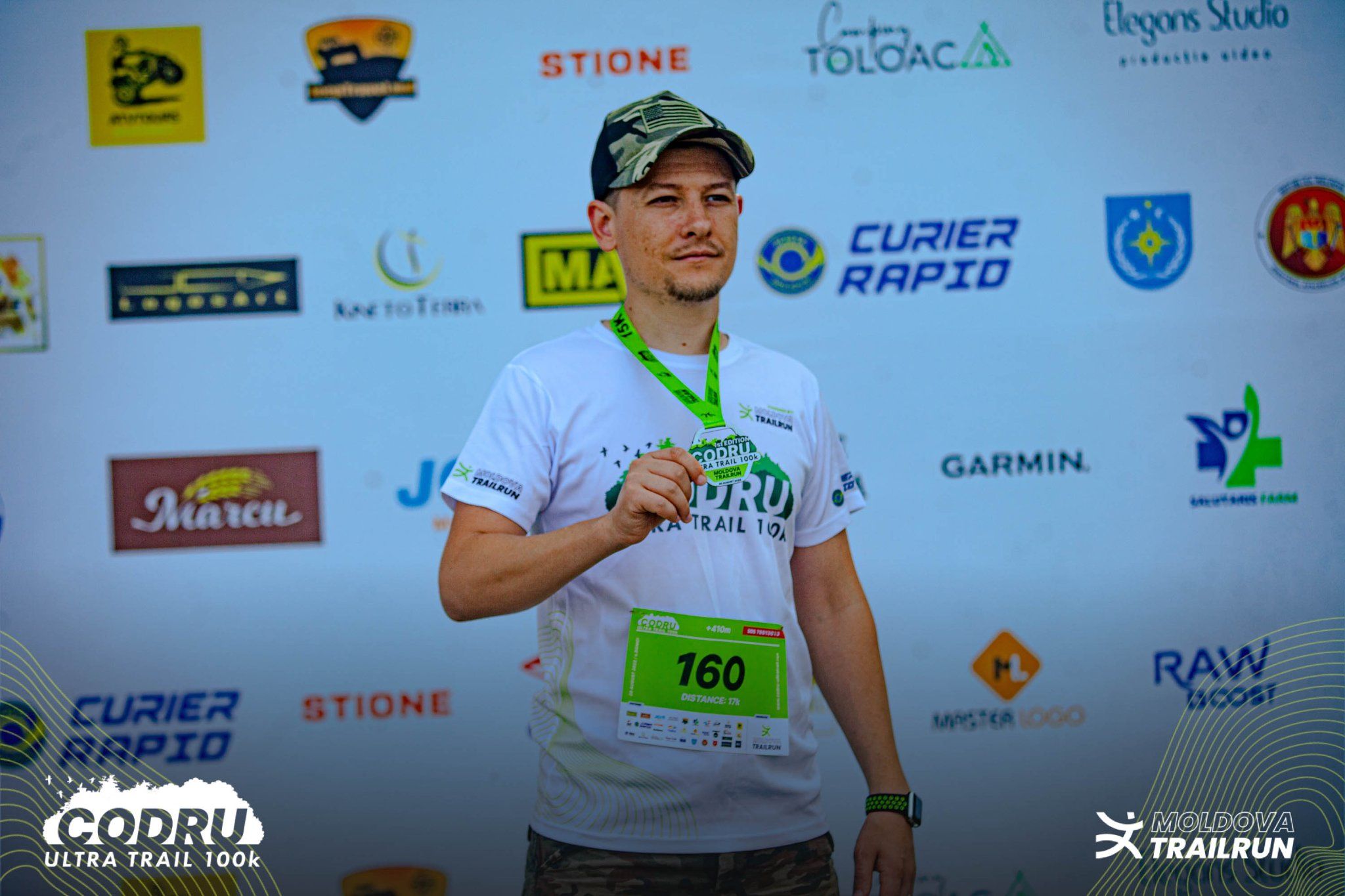 Runner wearing bib number 160 proudly displays medal at Codru Ultra Trail 100k finish line event.