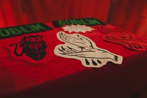 Red fabric patches featuring goblin-themed designs including a lion, dove, and monster on a red background.