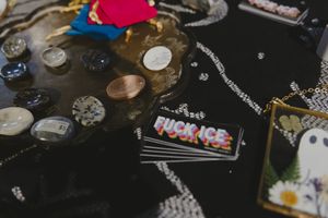 Table display with crystals, coins, and a Fuck ICE sticker at a market vendor booth.