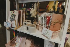 Retail shelf with notebooks, mugs, and stationery items in a boutique gift shop.
