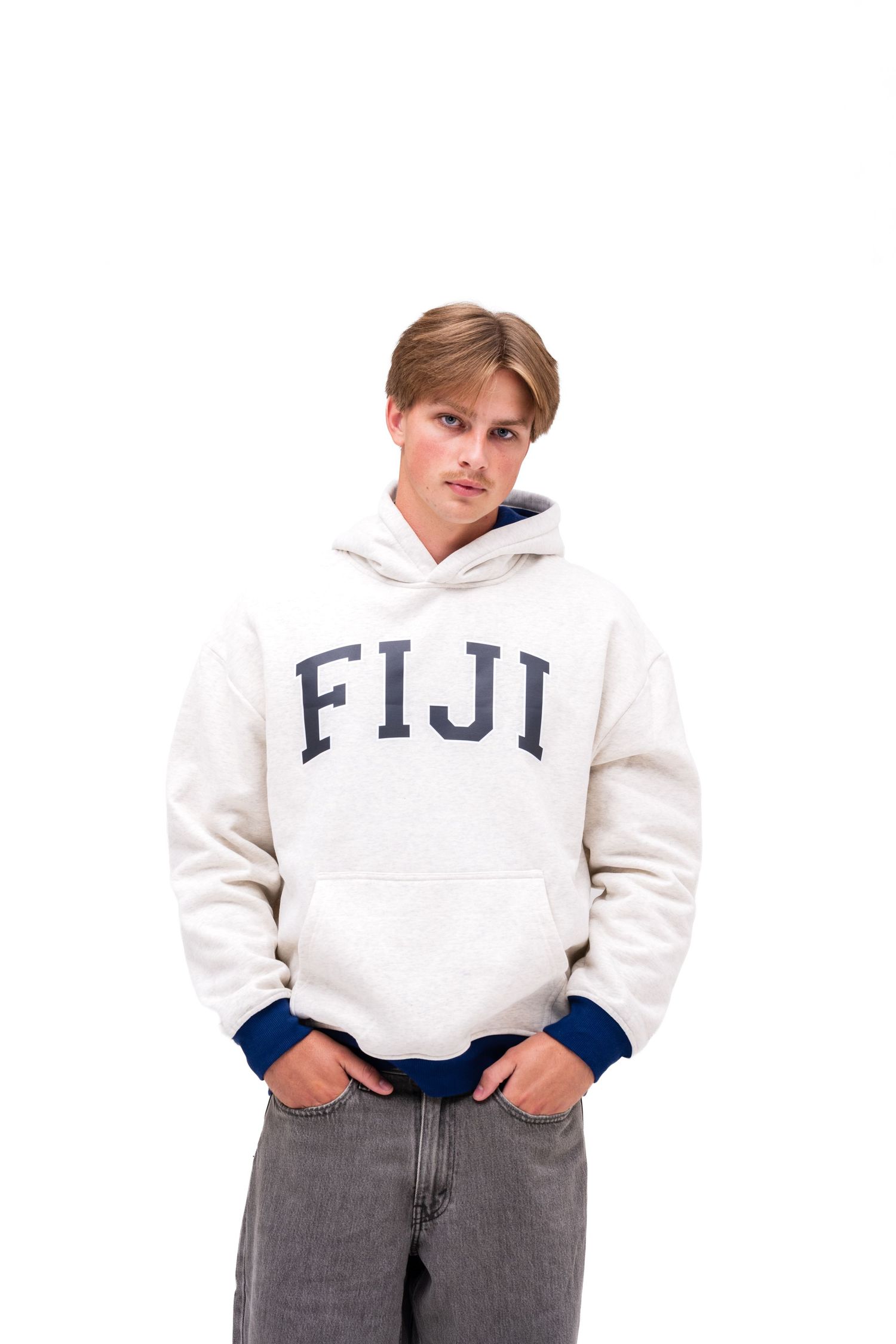 A white male model models an off-white hoodie with blue cuffs with the text "FIJI" on the front. A hoodie from The Hang Loose Hut.