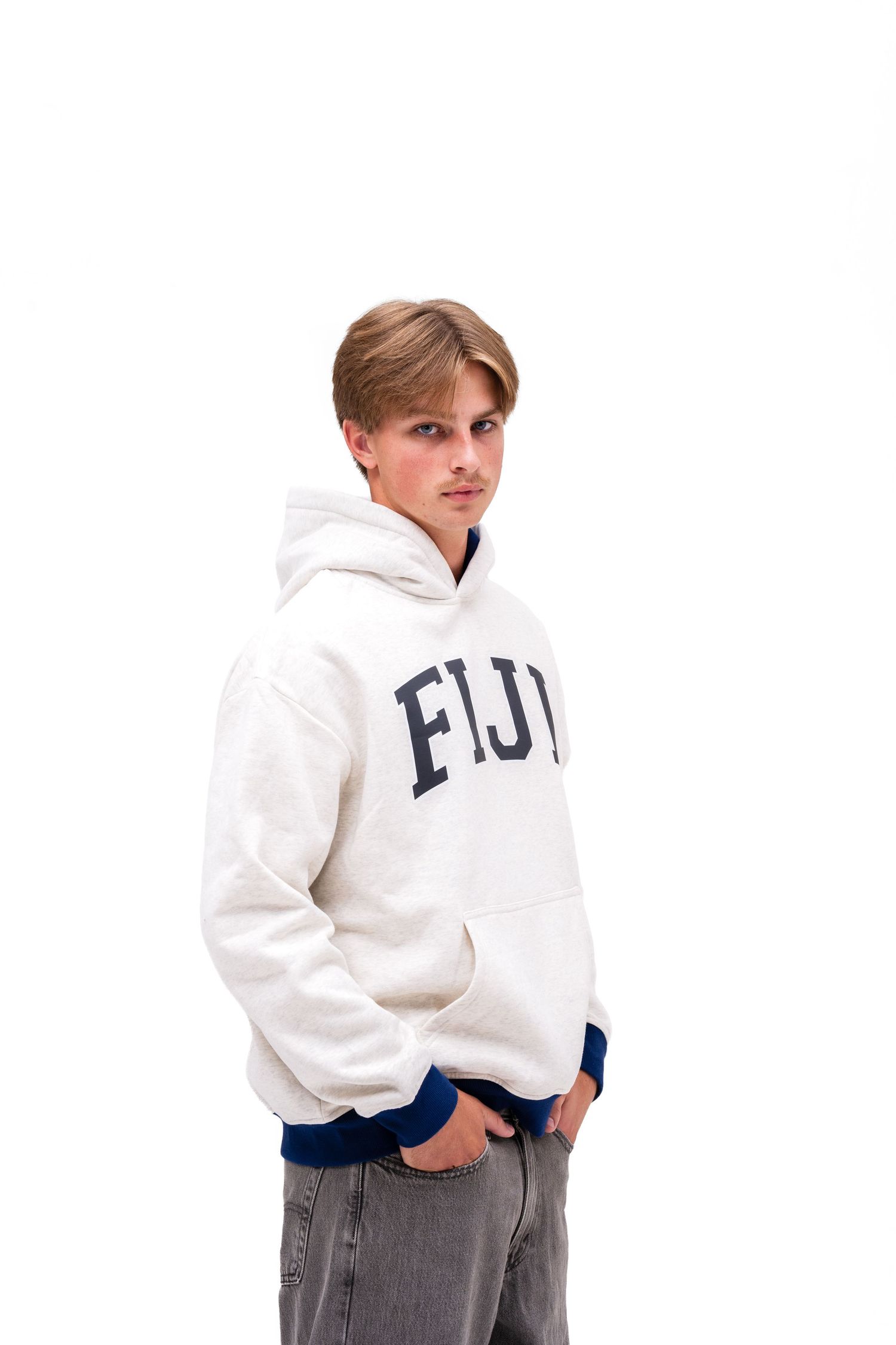 A white male model models an off-white hoodie with blue cuffs with the text "FIJI" on the front. A hoodie from The Hang Loose Hut.