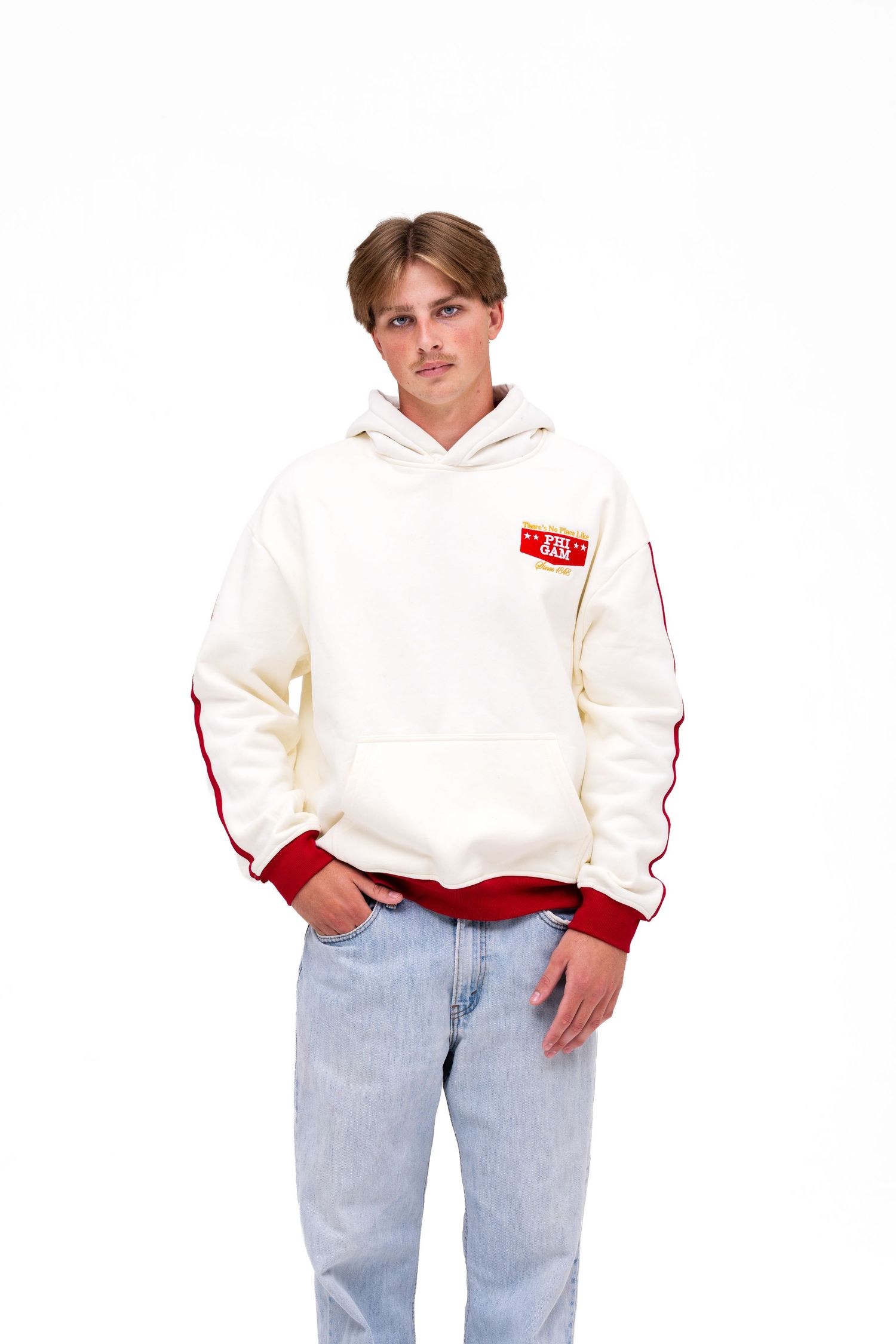 A white male model wears a light cream-colored hoodie with red cuffs with the text "PHI GAM" on the front. A hoodie from The Hang Loose Hut.
