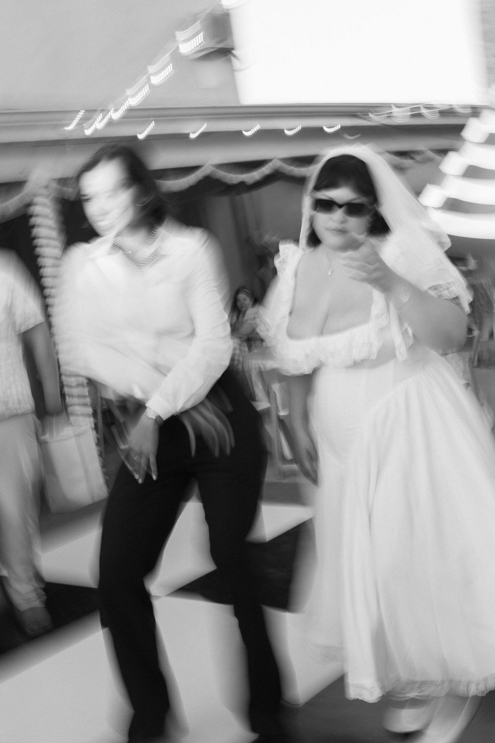 Blurry black and white photo of couple dancing at wedding reception.