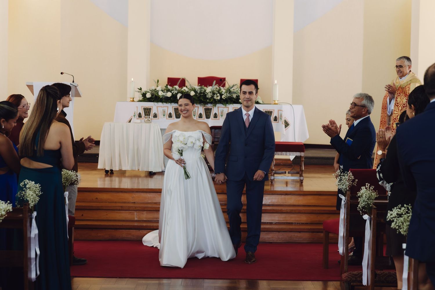 Bride and groom walk down the church aisle together after their wedding ceremony.
