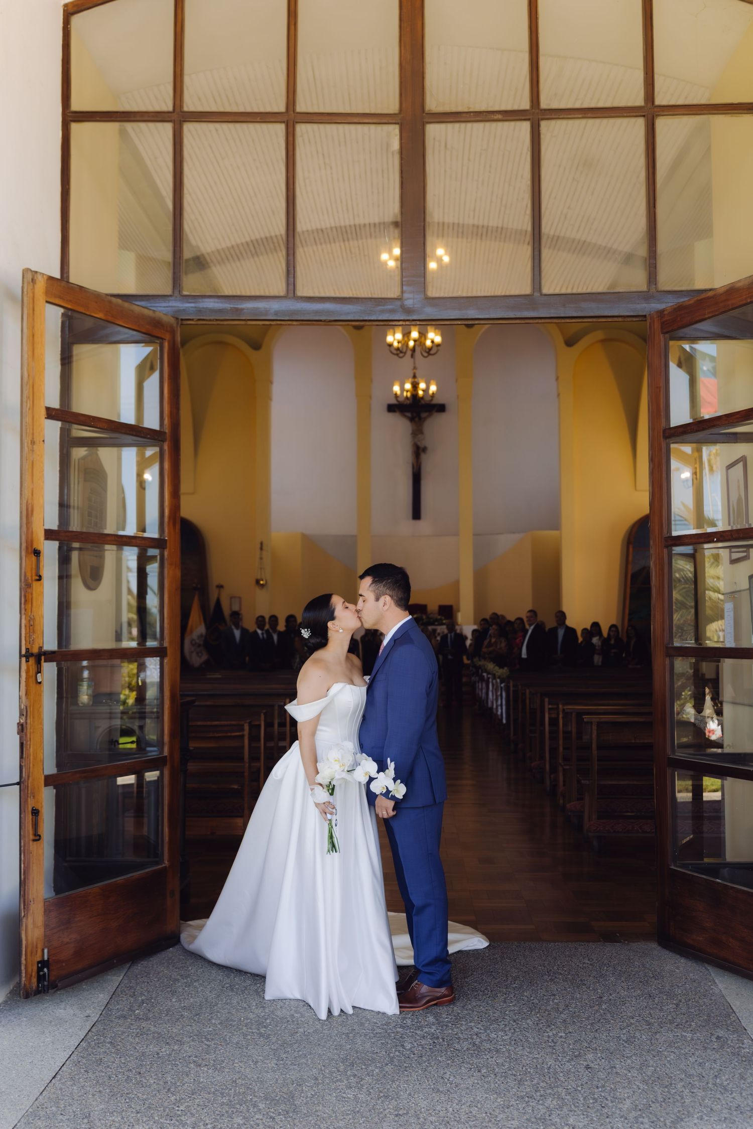 Bride and groom kiss in the doorway of a church after their wedding ceremony.
