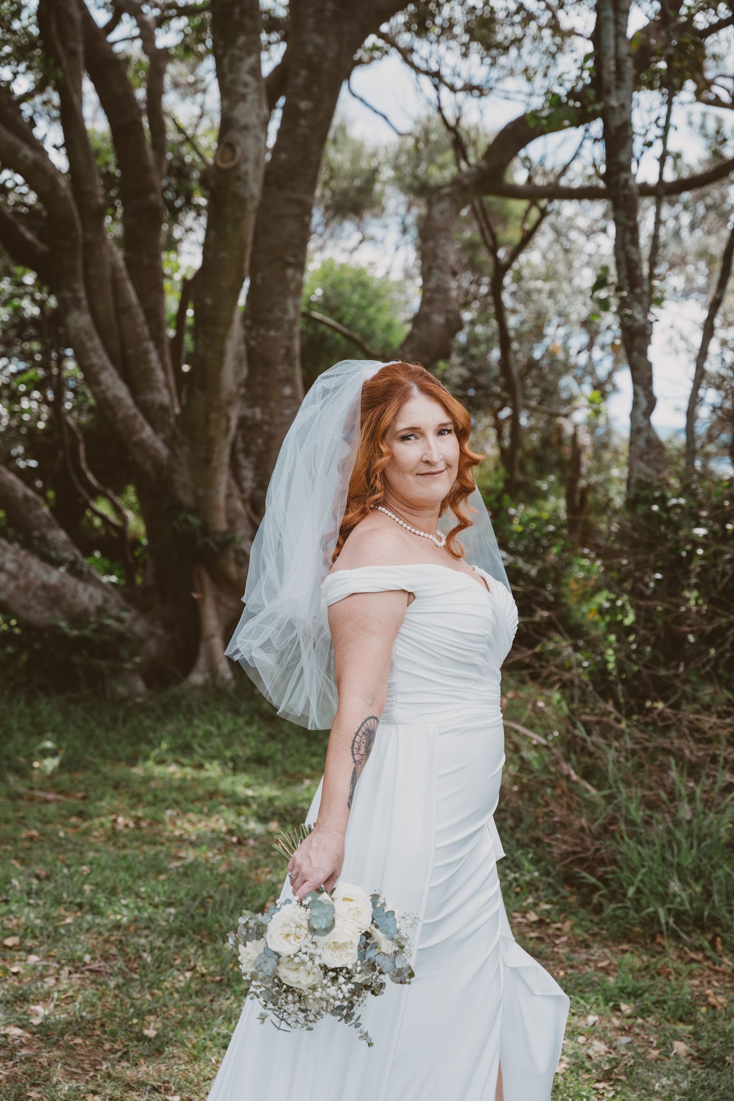Bride in an off-shoulder gown and veil under coastal trees - Wollongong elopement photographer bridal portrait