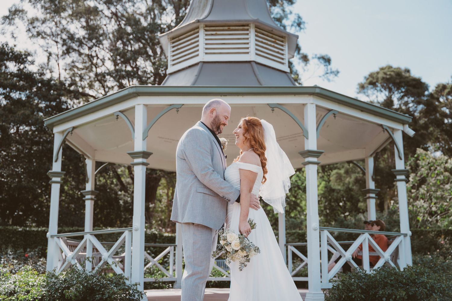 Bride and groom inside a white garden gazebo - classic elopement portraits in a park