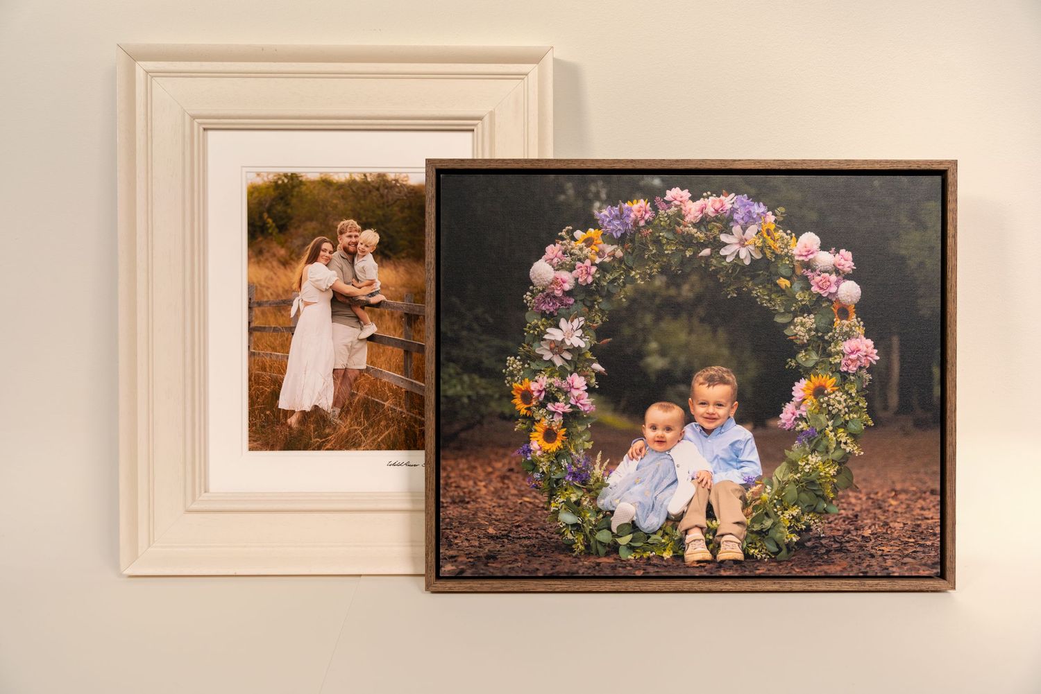 Three framed family portrait photos displayed on a beige wall, featuring outdoor maternity and family photography sessions.