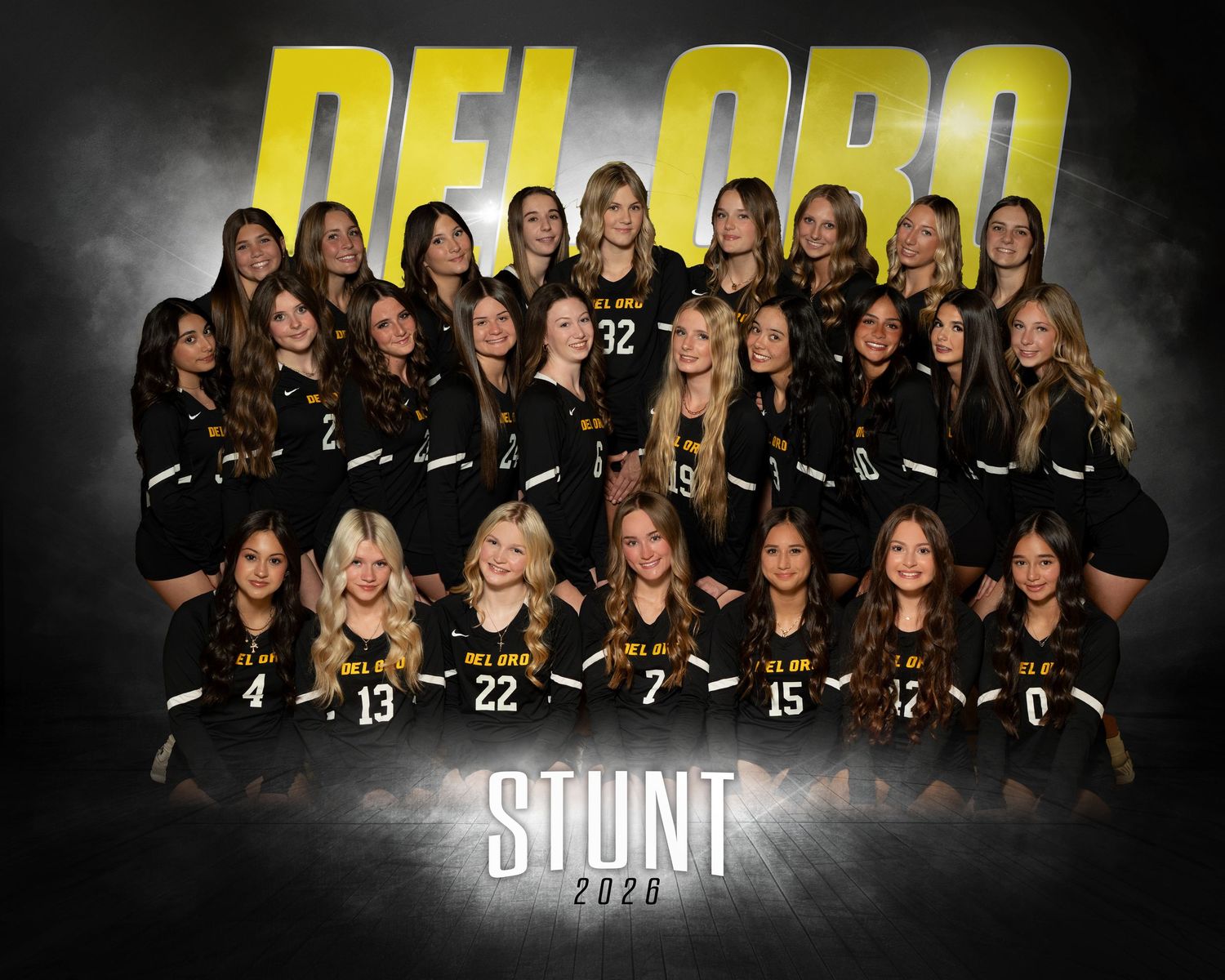 Del Oro High School Stunt team 2025 group photo in black uniforms posed in front of dramatic smoky background.