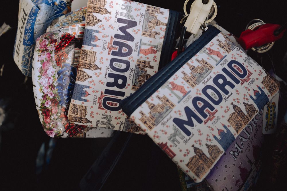 Colorful Madrid-themed souvenir pouches and bags displayed at a tourist gift shop in Spain.