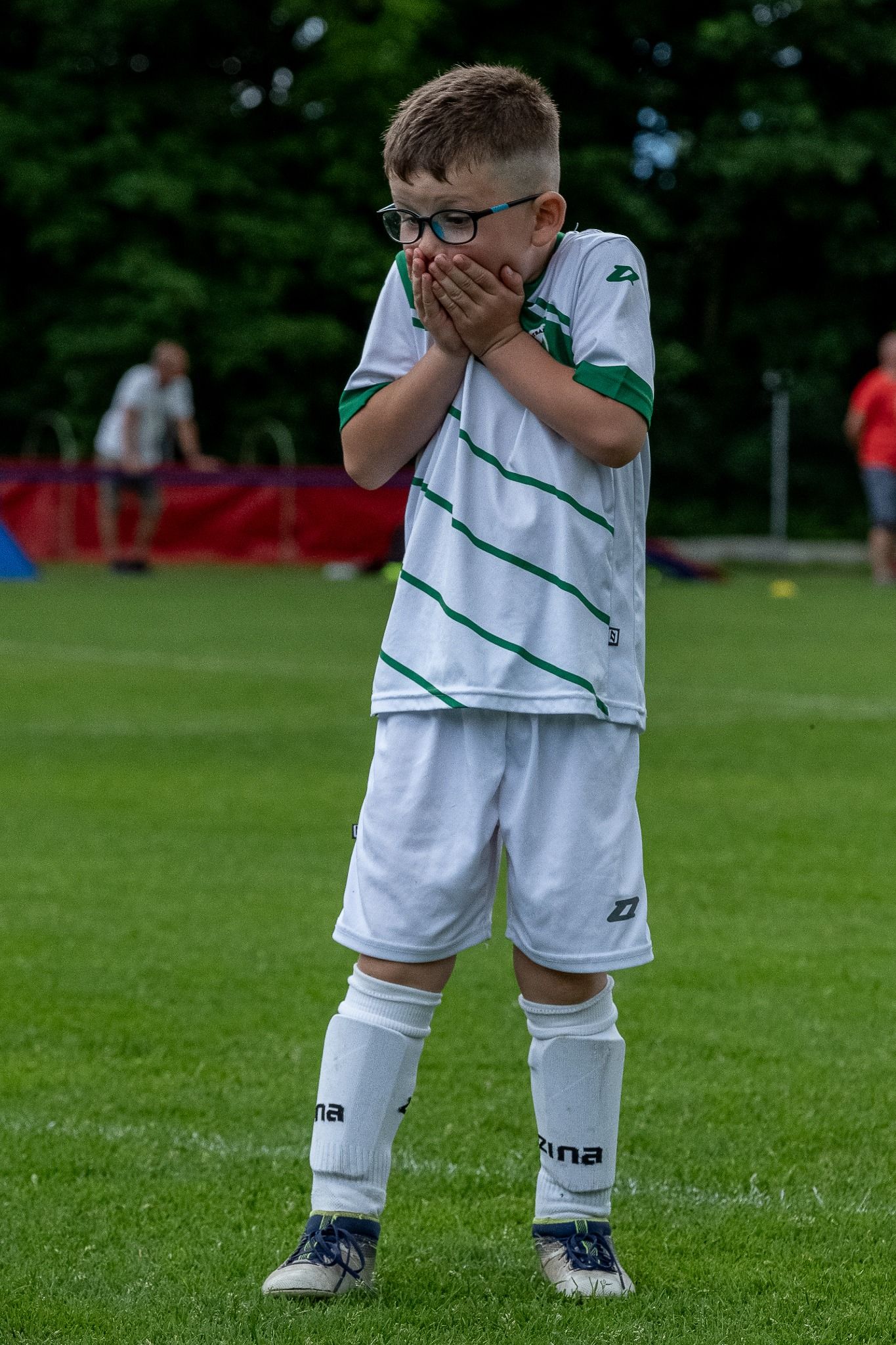 Mladý fotbalista reaguje na průběh utkání.