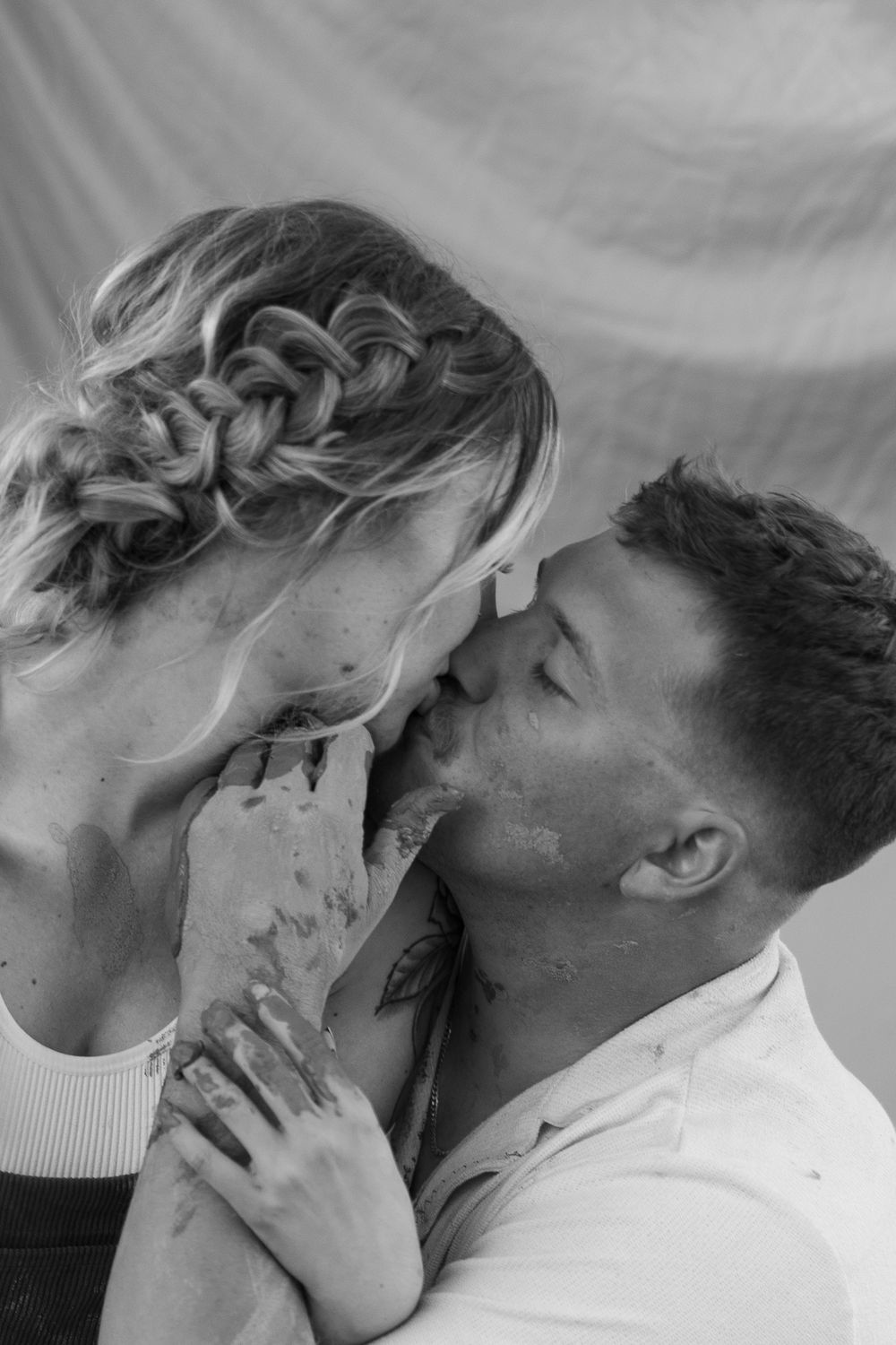 An intimate black and white portrait of a couple sharing a tender moment.