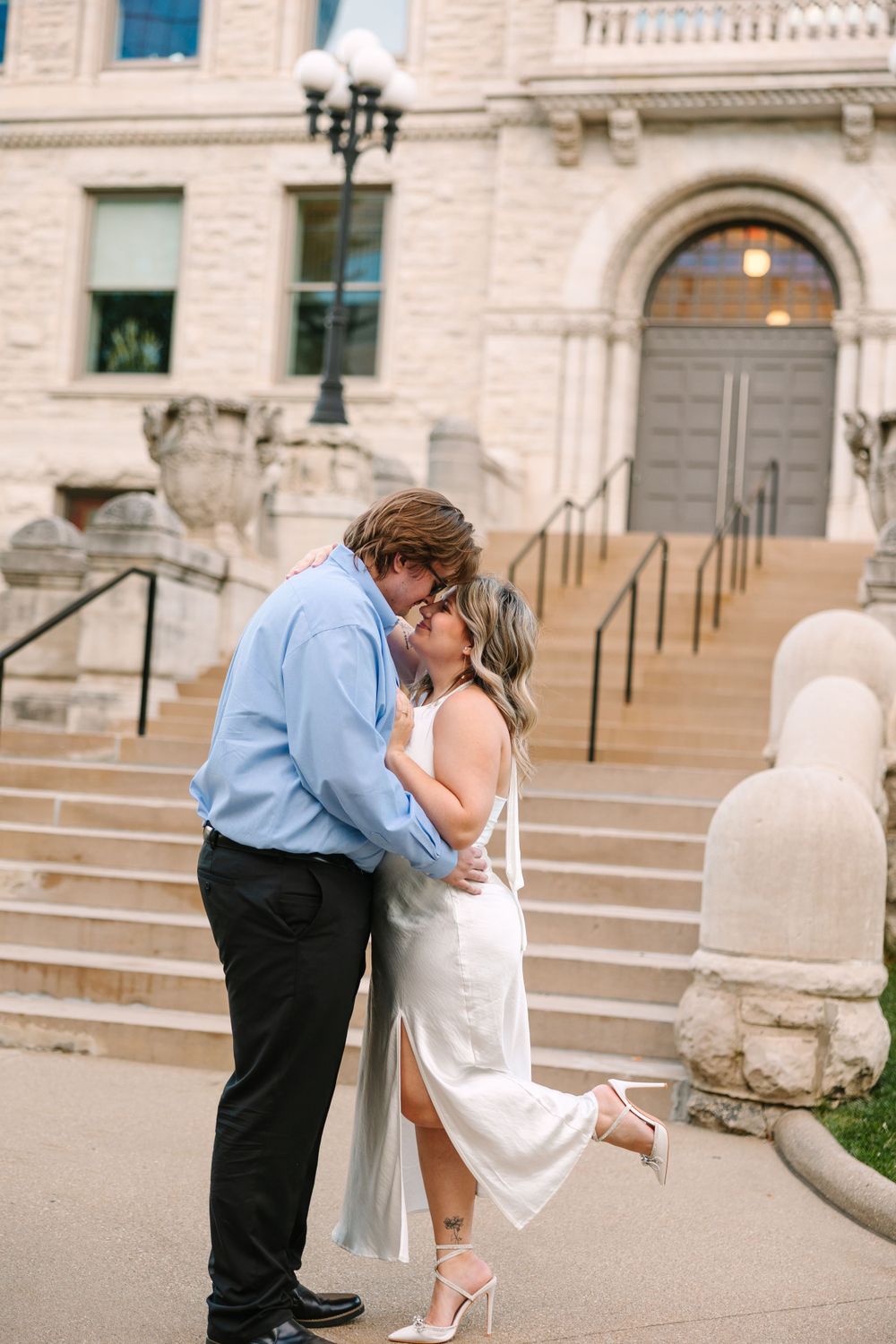 Romantic moment captured on grand stone steps of historic building.