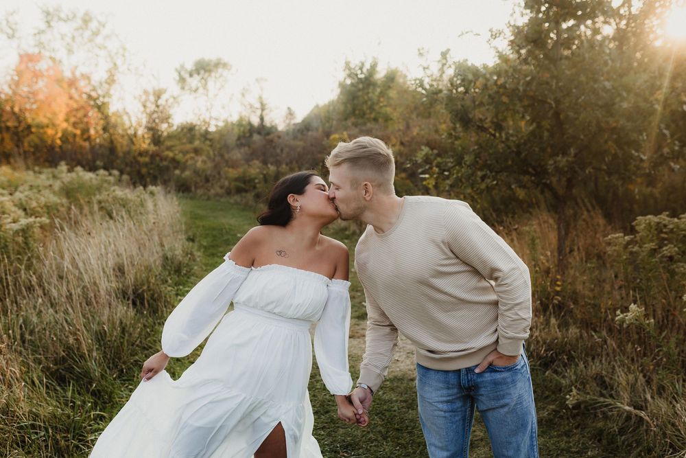 Playful couple sharing a laugh together during outdoor engagement photo session.