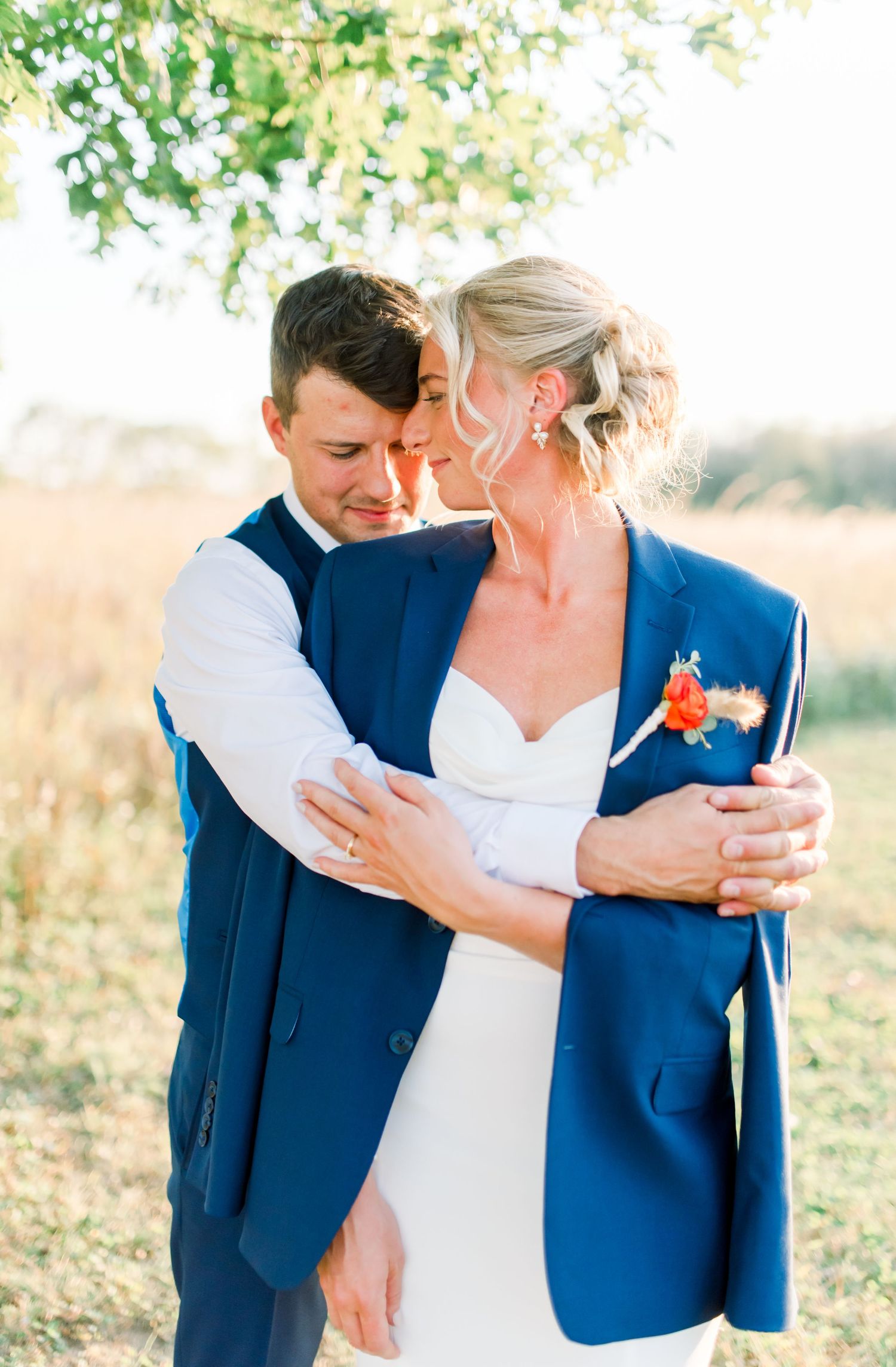 Romantic wedding portraits showing tender moments between couple in navy suit and white dress.