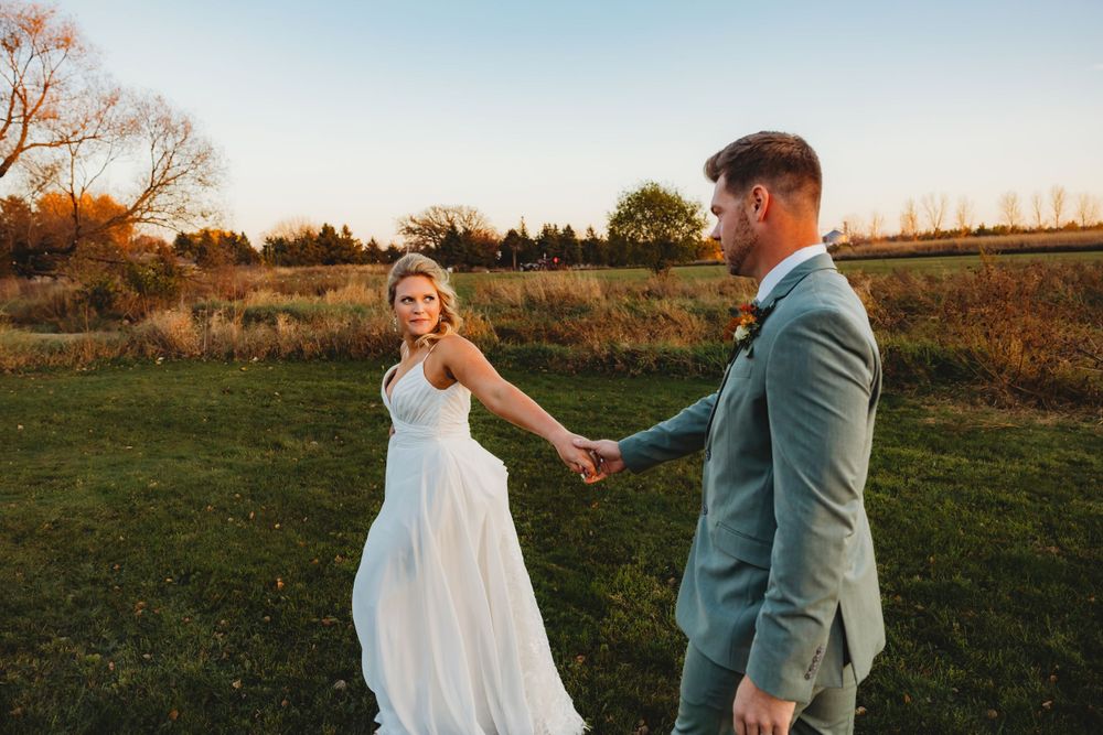 Couple dancing together in field during sunset wedding photoshoot.