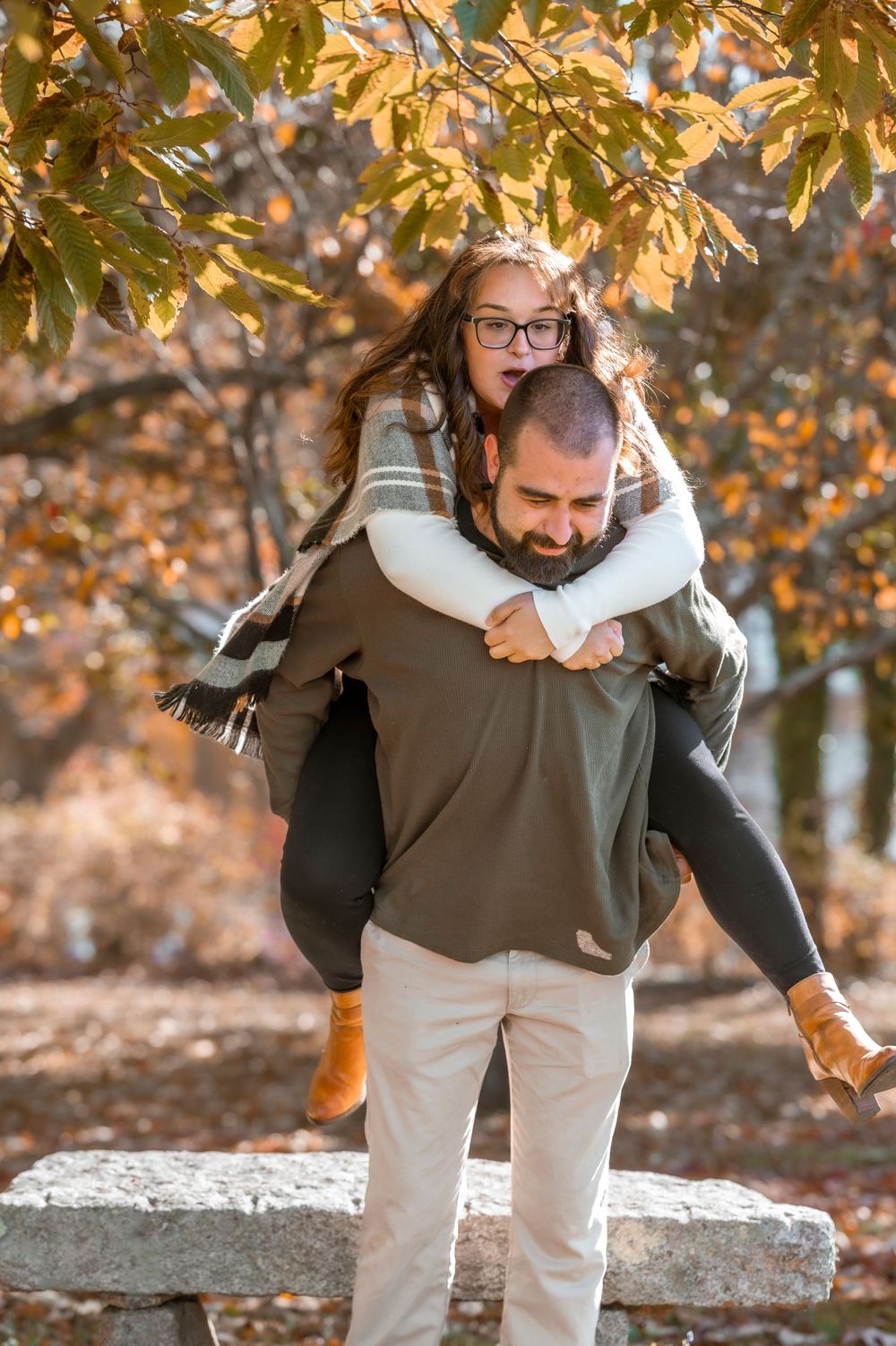 A playful piggyback ride captured during autumn with golden leaves in the background.