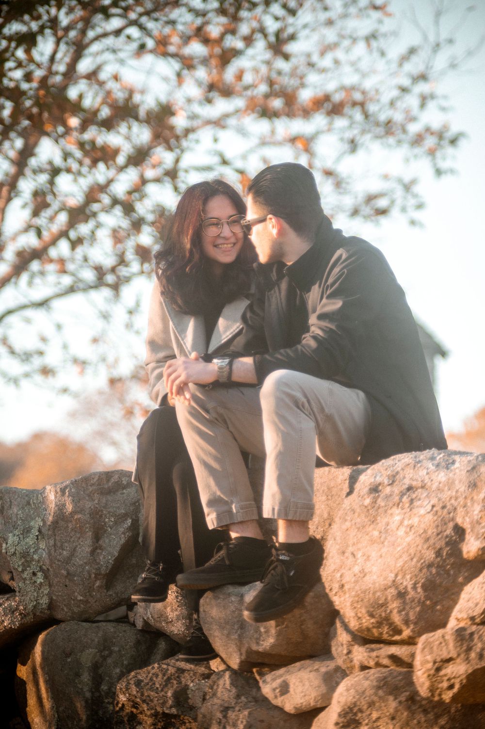 Romantic moment shared on rocky outcrop during golden hour.