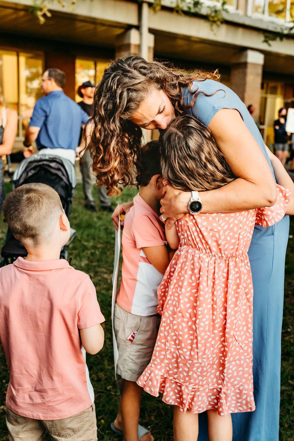 Family members in pink and coral outfits sharing tender moments outdoors in Waterbury, CT.