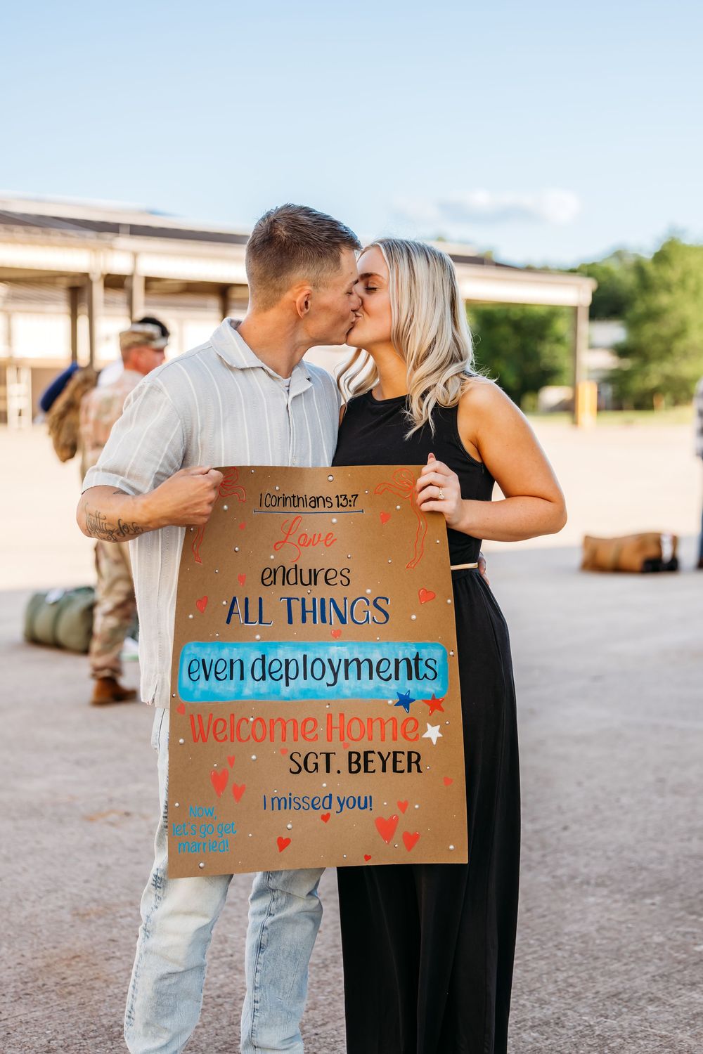 Couple holds sign following deployment during a military homecoming