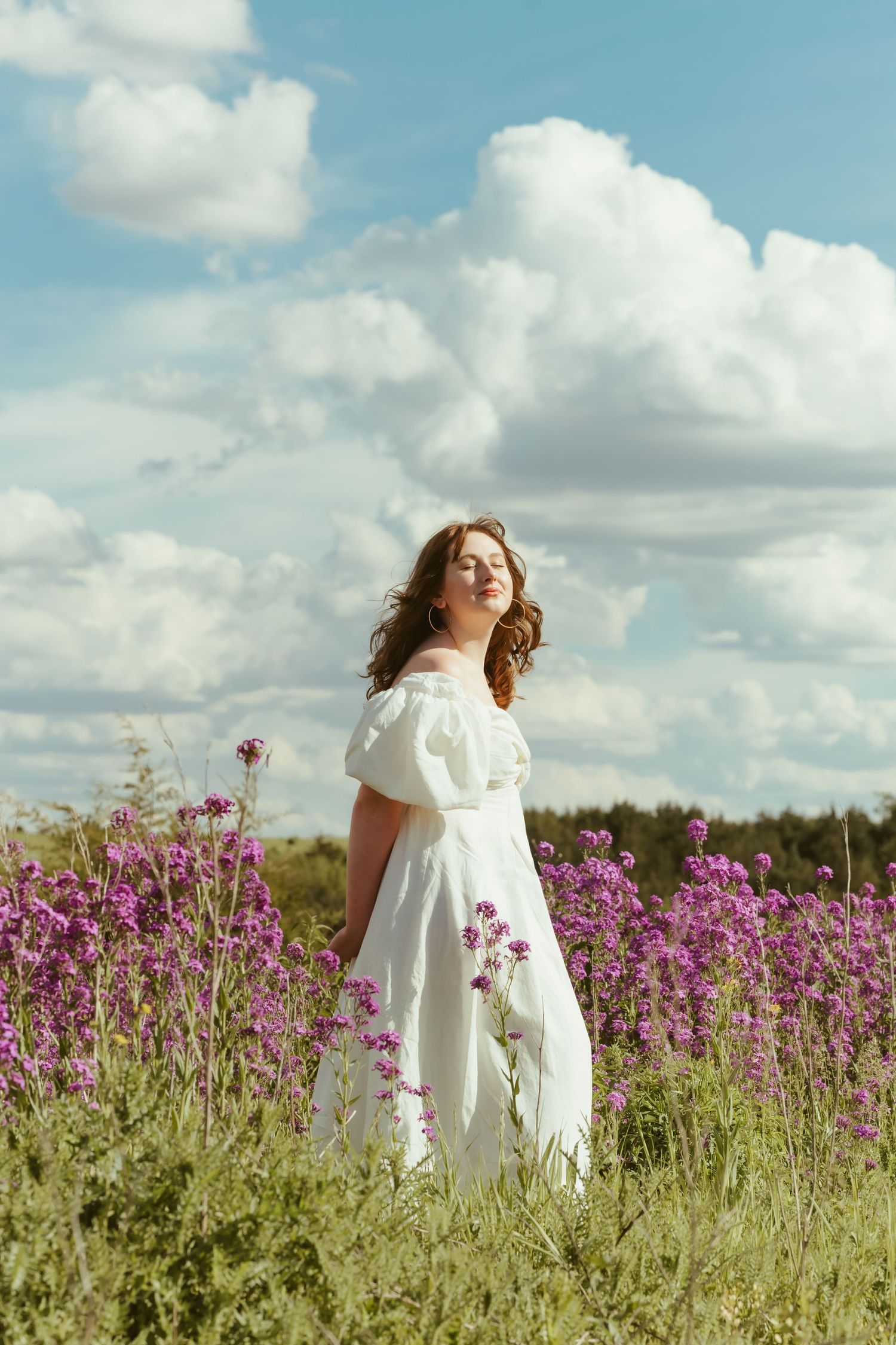 Series of dreamy photos showing white dresses flowing in a field of purple wildflowers.