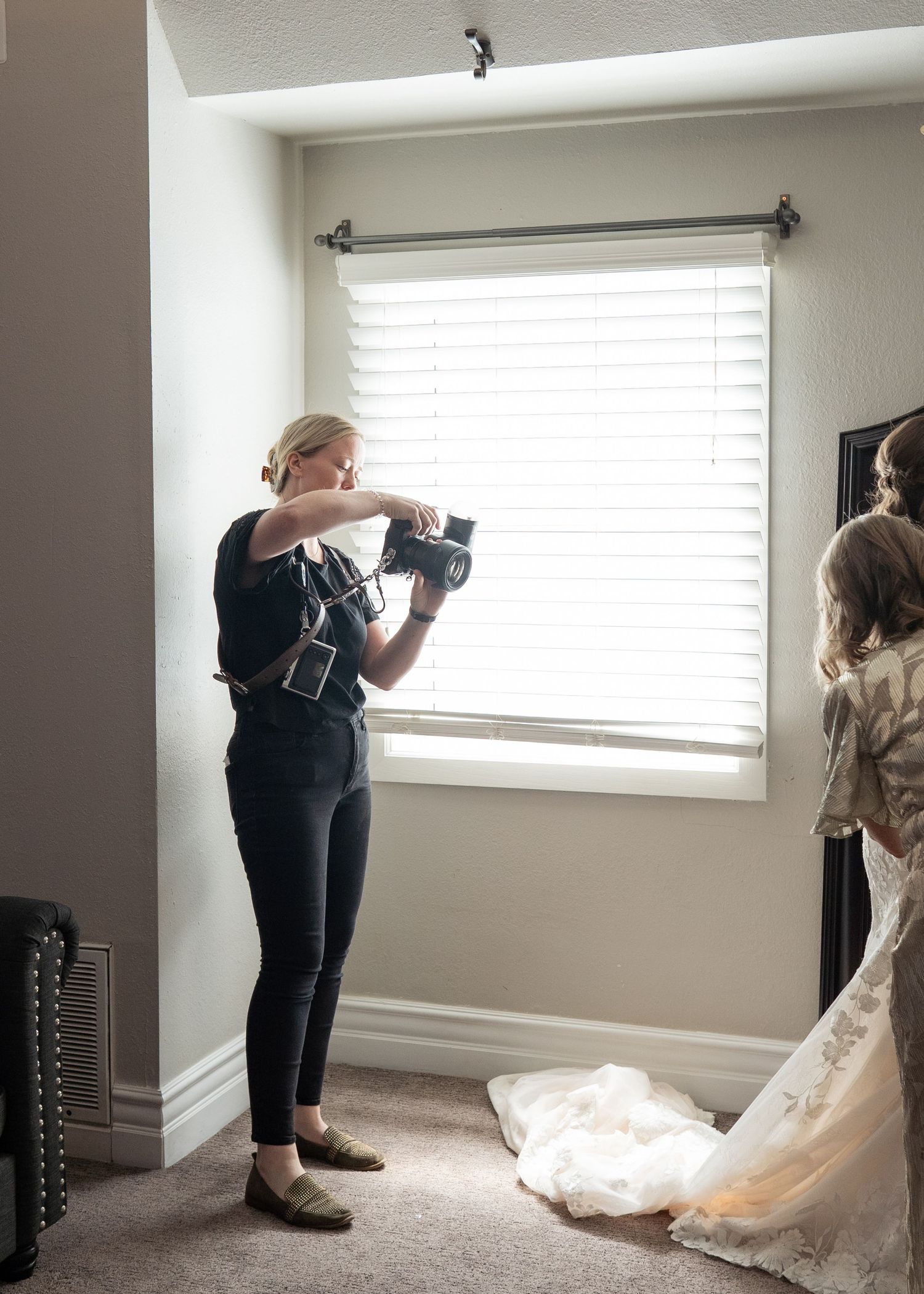 A wedding photographer capturing a bride getting ready in her wedding dress at Forest House Lodge in Northern California.