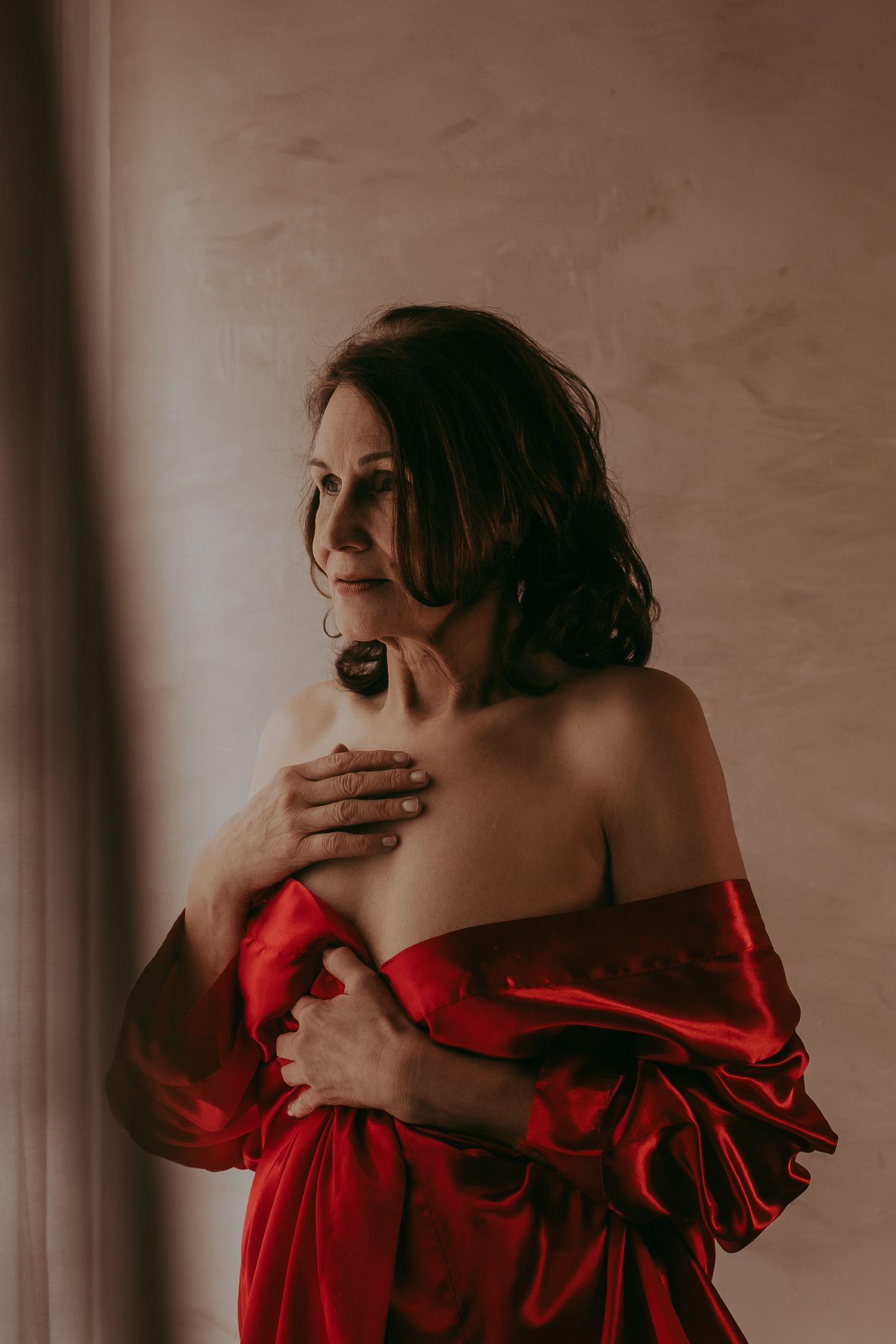 Vrouw in glamoureuze outfit poseert met een krachtige uitstraling in een moderne studio