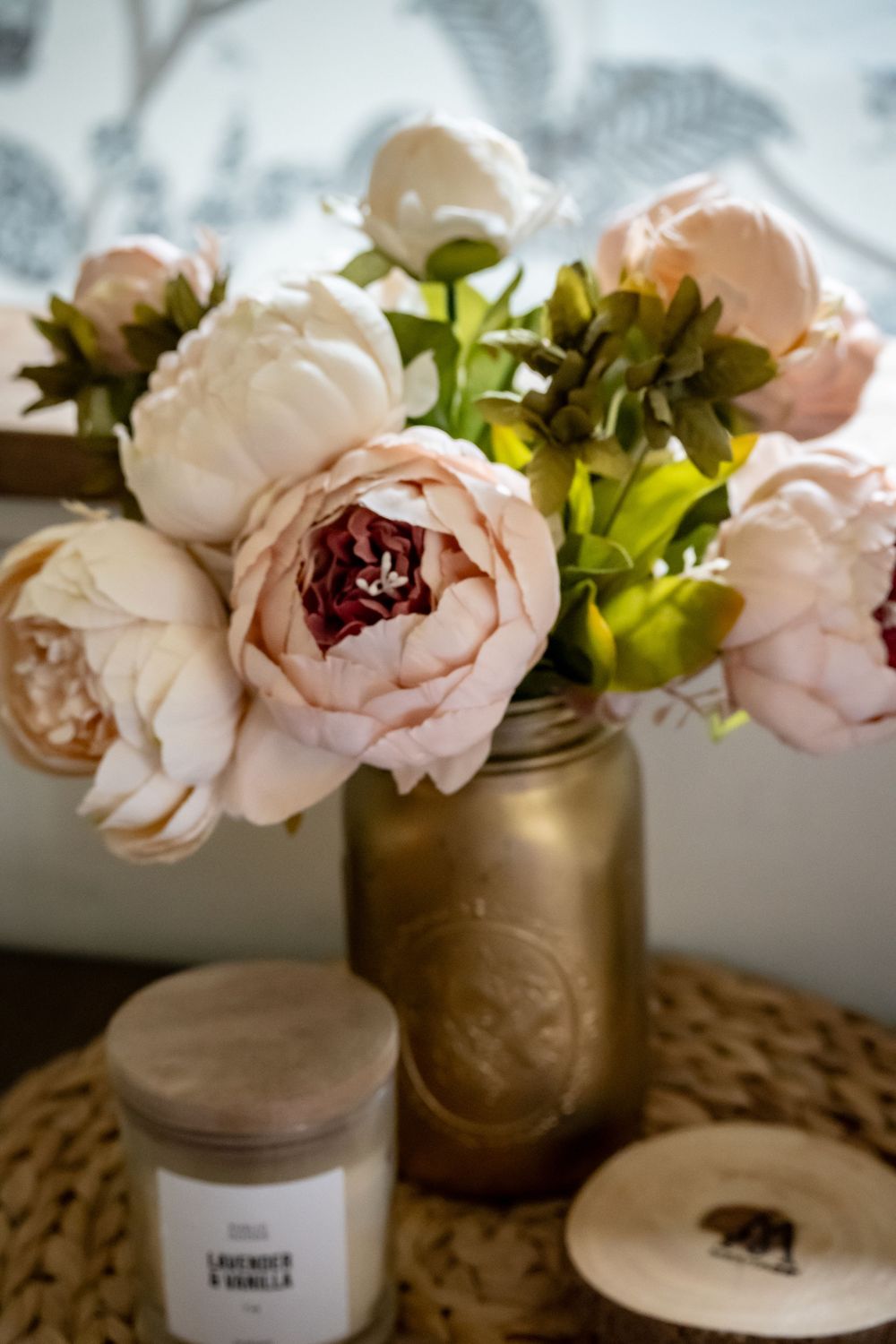 Delicate pink roses arranged in frosted gold vases against a soft natural background.