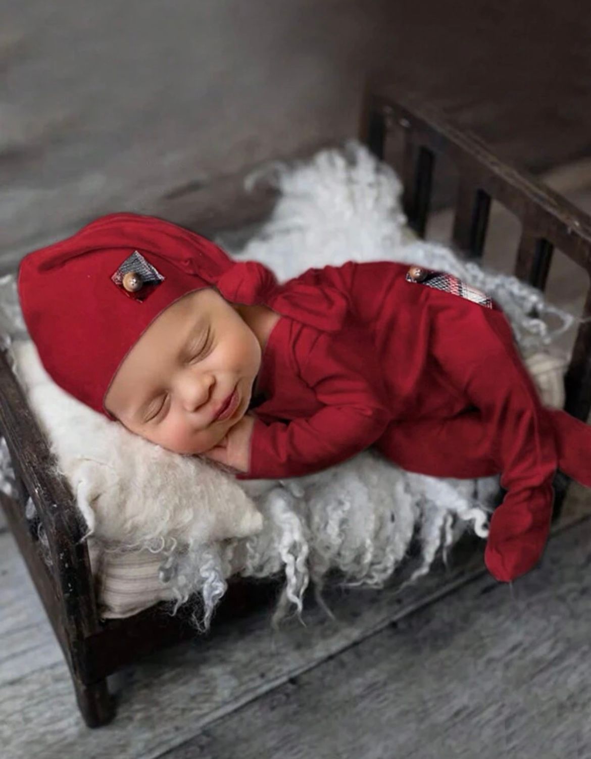 Sleeping figure in red outfit on white fluffy surface against dark background.