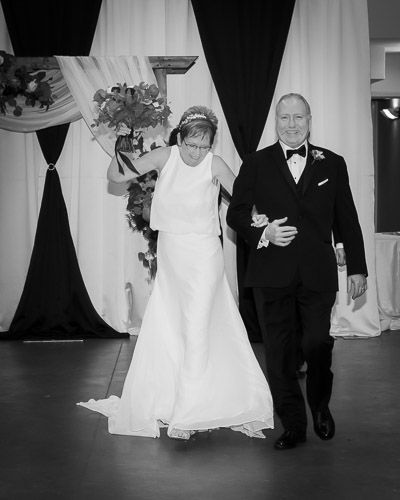A couple makes their grand entrance at their wedding reception in black and white