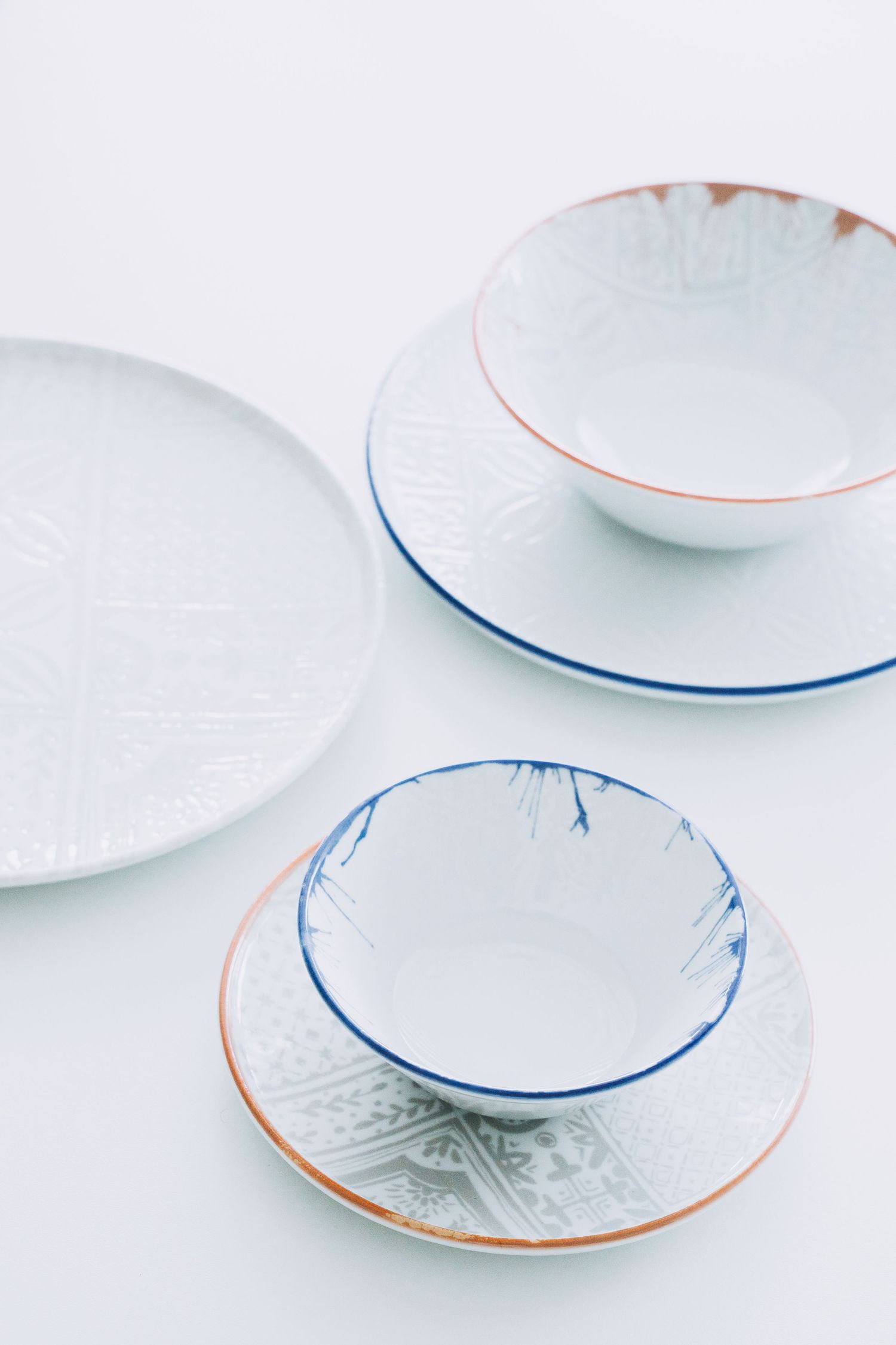 Digitally printed porcelain plates and bowls with mosaic patterns, arranged on a hard porcelain.