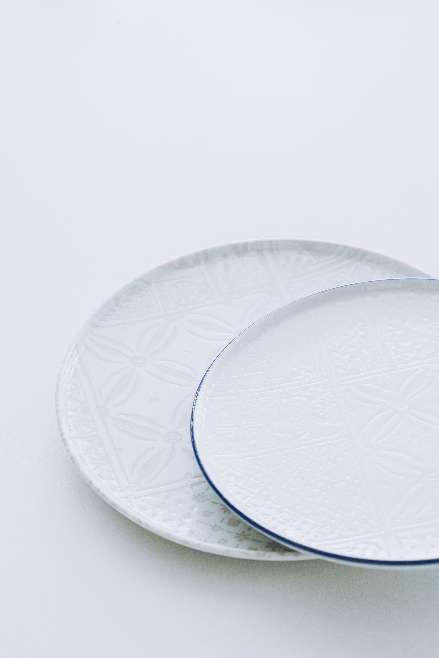 Digitally printed porcelain plates and bowls with mosaic patterns, arranged on a hard porcelain.